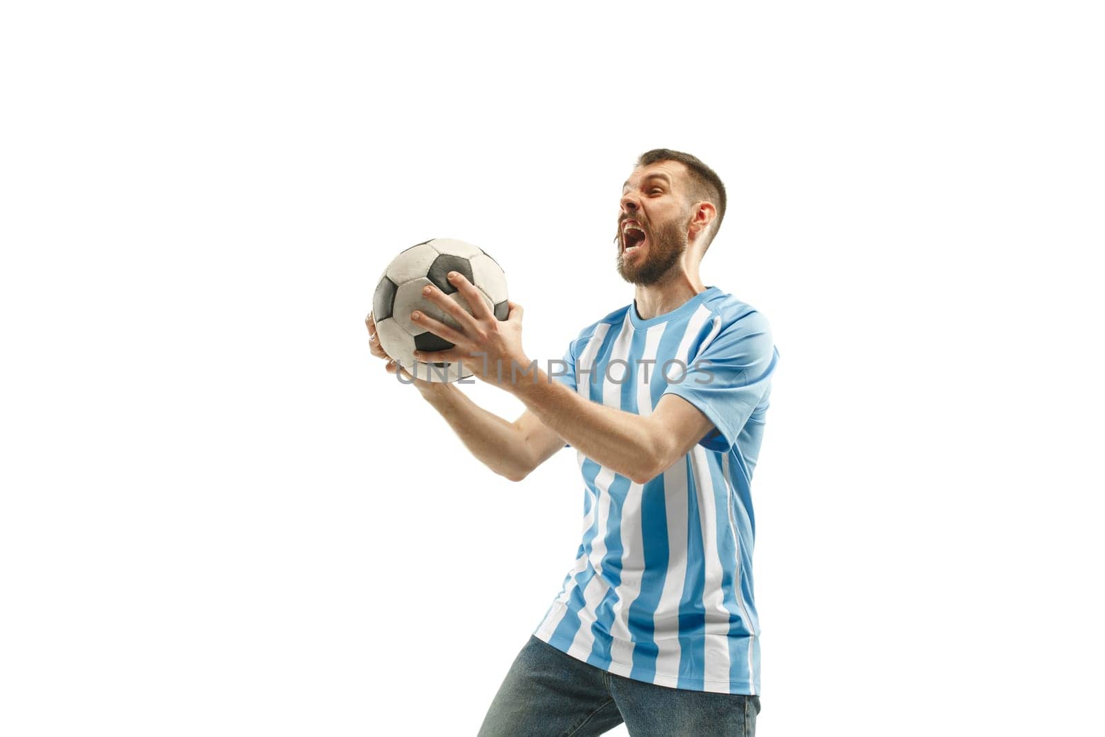The young Argentinean fan celebrating on white background. The young man in soccer football uniform as winner isolated at white studio. Fan, support concept. Human emotions concept.