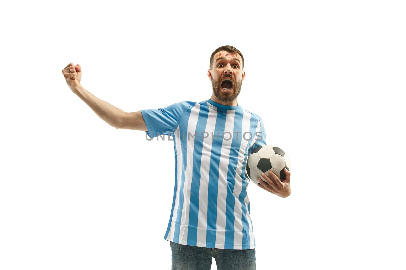 The young Argentinean fan celebrating on white background. The young man in soccer football uniform as winner isolated at white studio. Fan, support concept. Human emotions concept.