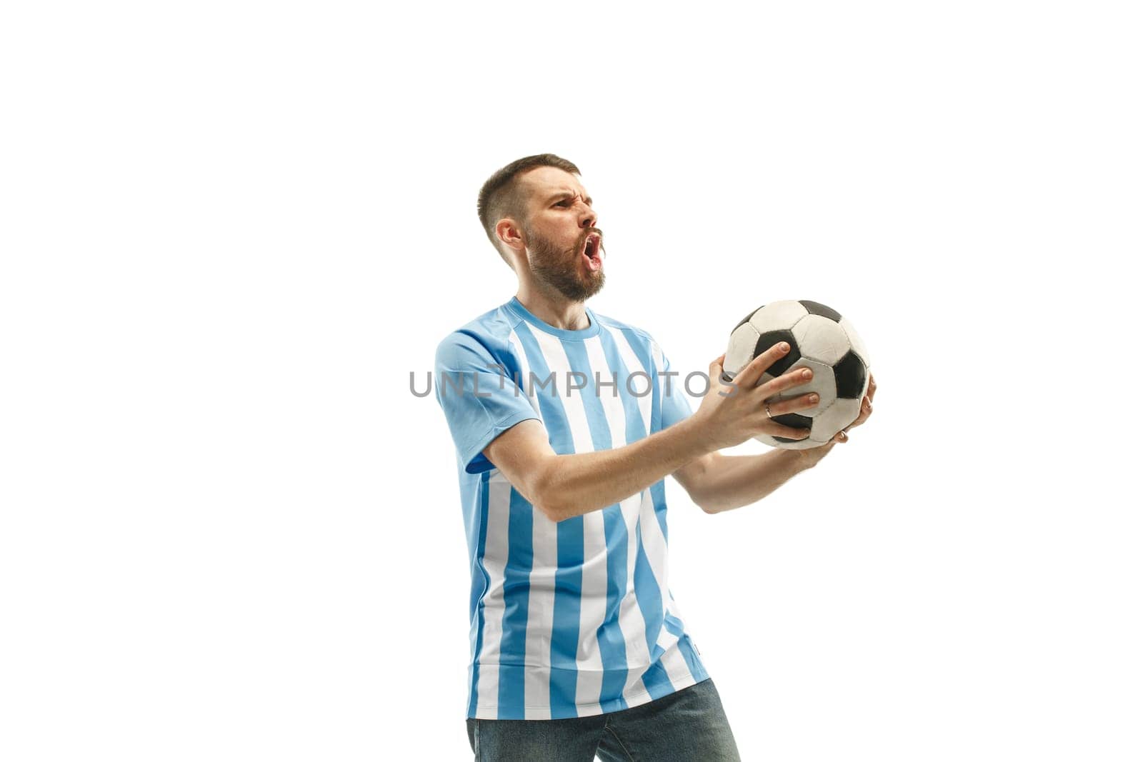 The young Argentinean fan celebrating on white background. The young man in soccer football uniform as winner isolated at white studio. Fan, support concept. Human emotions concept.