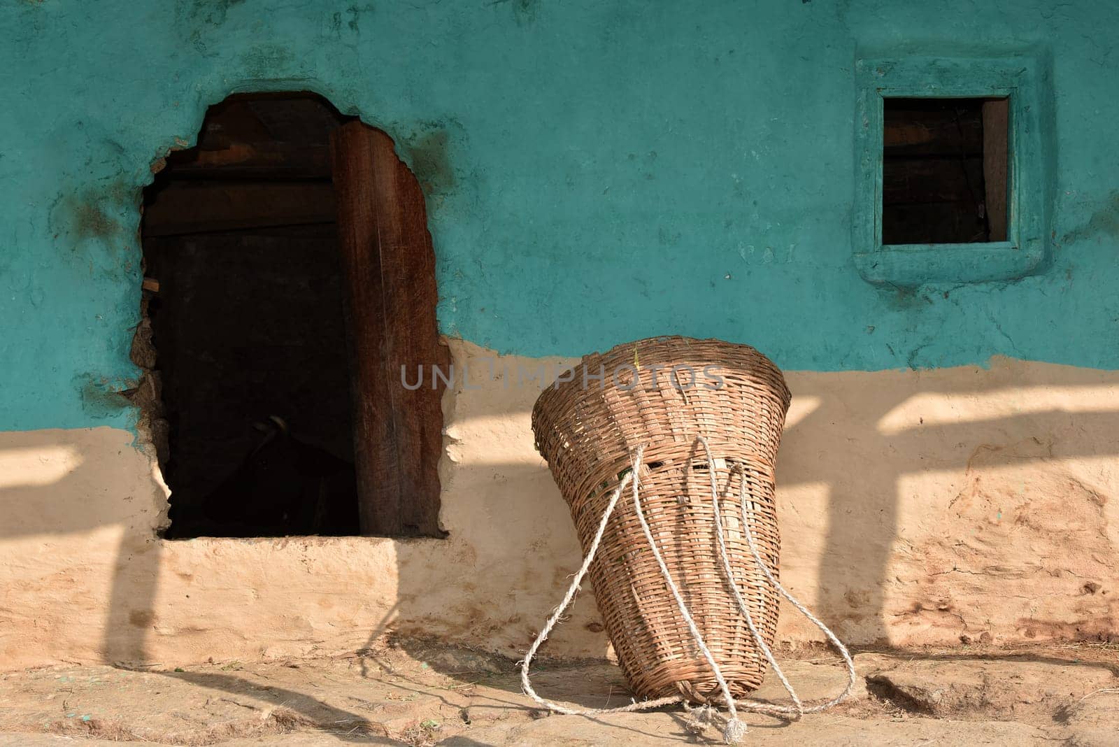 Mud wall, small door and window of a traditional house where livestock live on the ground floor in northern Indian villages, Shimla, Himachal Pradesh, India.