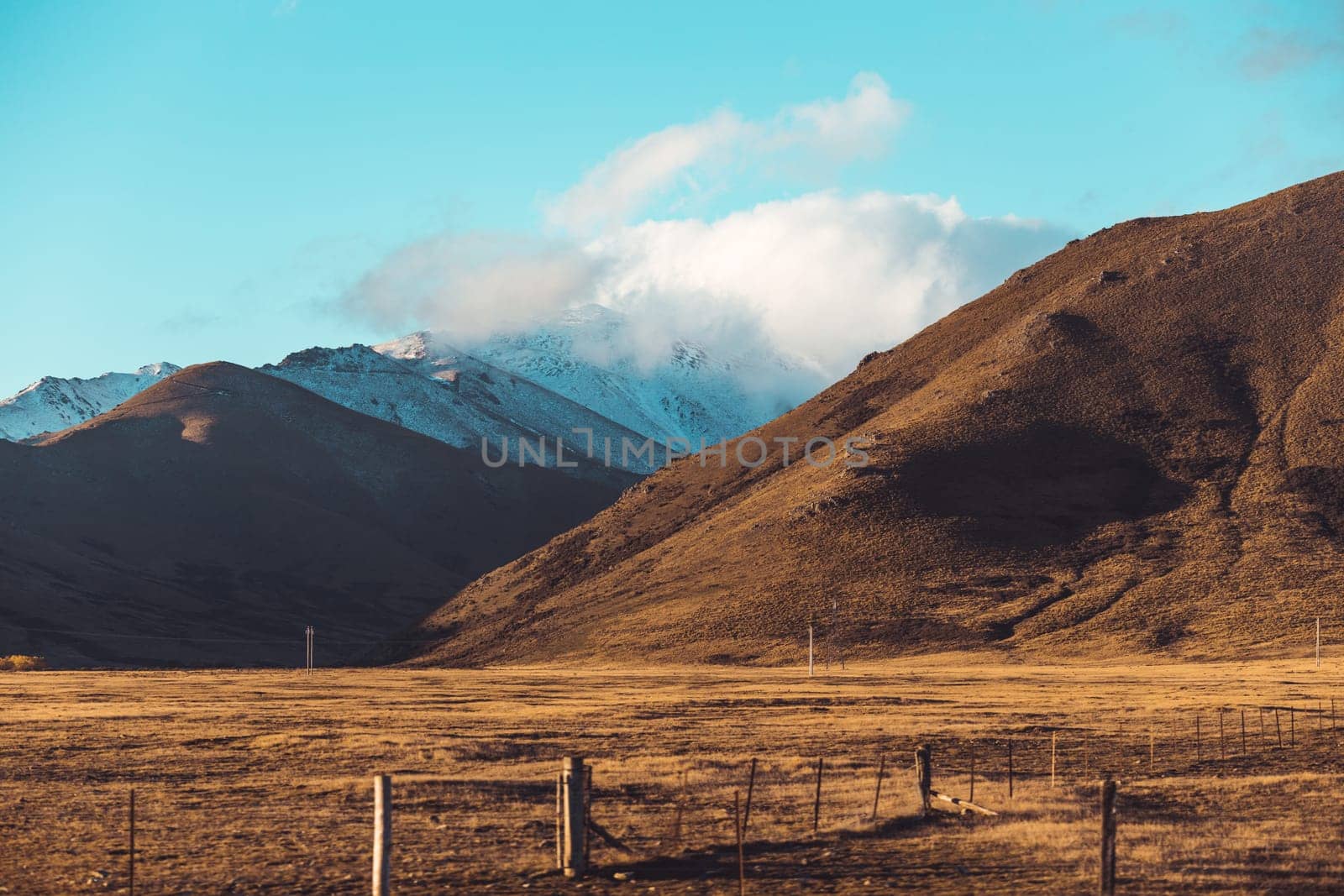 Road travel in the green mountains of New Zealand view from car window. Scenic peaks and ridges. Beautiful background of amazing nature.