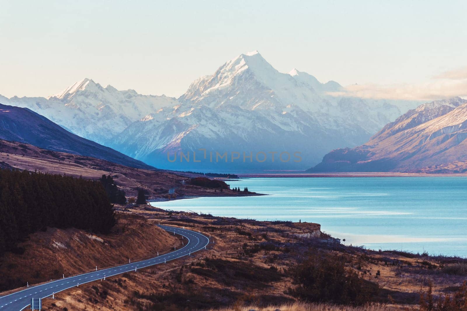 Road travel in the green mountains of New Zealand view from car window. Scenic peaks and ridges. Beautiful background of amazing nature.