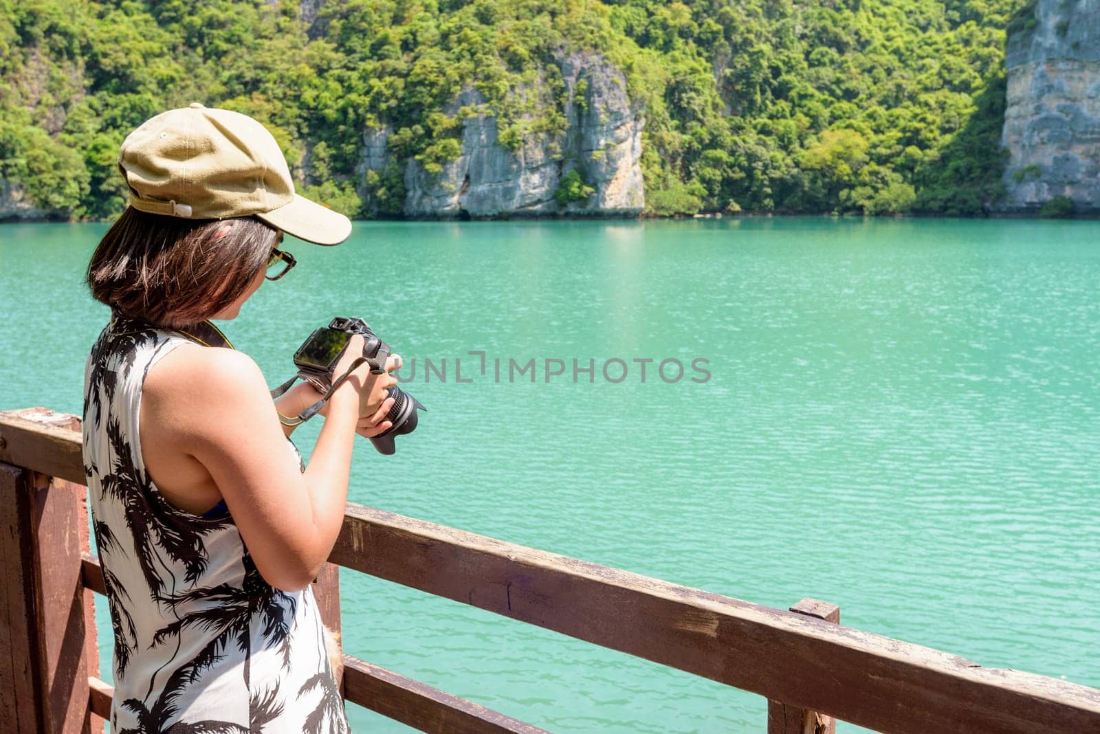 Woman tourist at Thale Nai on Koh Mae Ko island viewpoint looking at the camera after taking photos at Blue Lagoon (Emerald Lake) in Mu Ko Ang Thong National Park, Surat Thani, Thailand