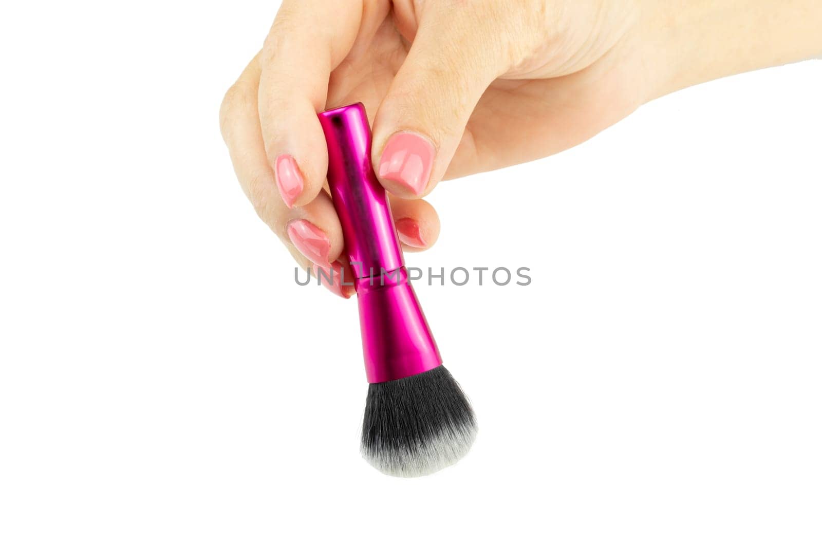 Closeup of female hand is holding professional makeup brush. Concept beauty.