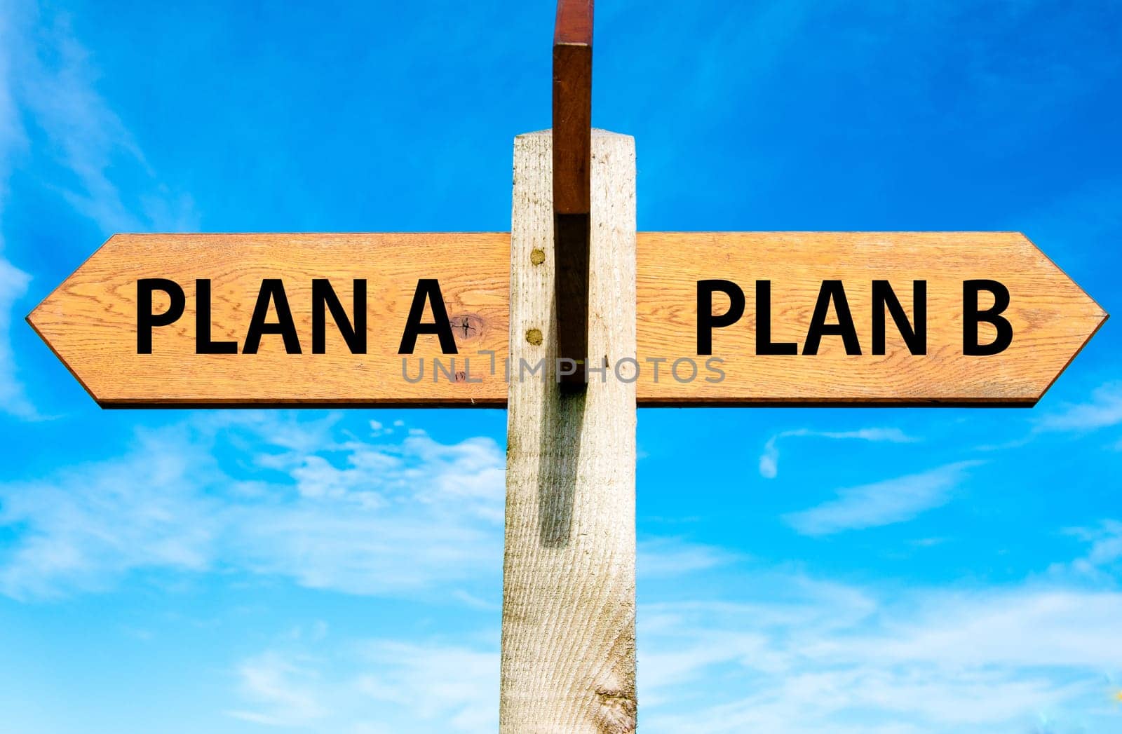 Blank wooden signpost with two arrows over clear blue sky with copy space, just add your text here