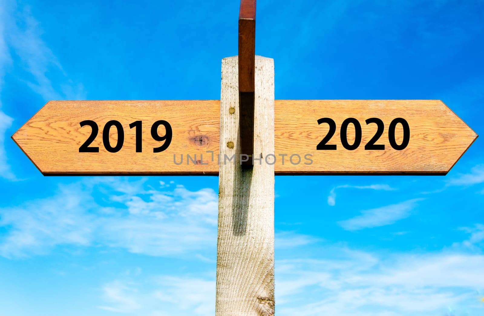 Blank wooden signpost with two arrows over clear blue sky with copy space, just add your text here