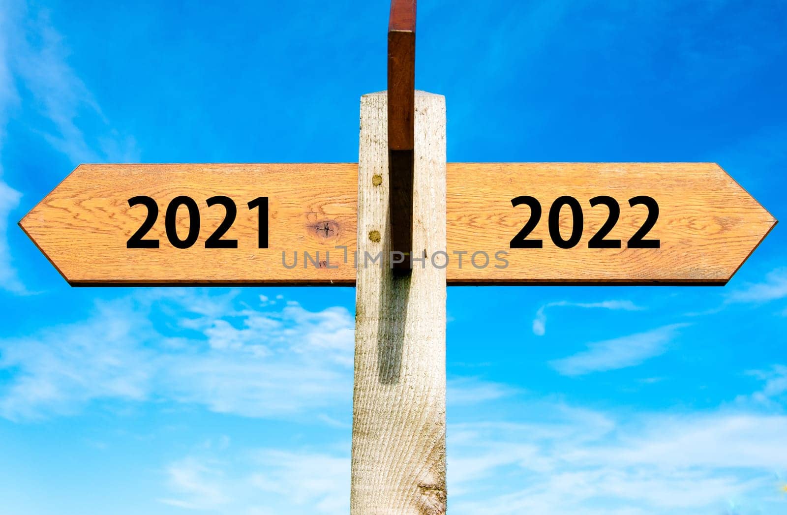 Blank wooden signpost with two arrows over clear blue sky with copy space, just add your text here