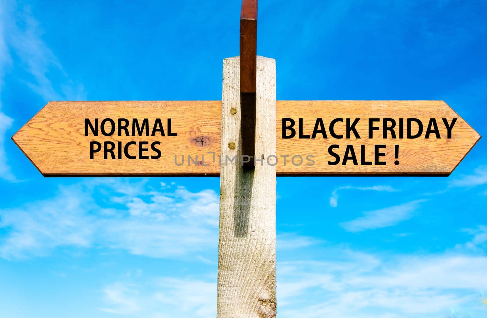 Blank wooden signpost with two arrows over clear blue sky with copy space, just add your text here