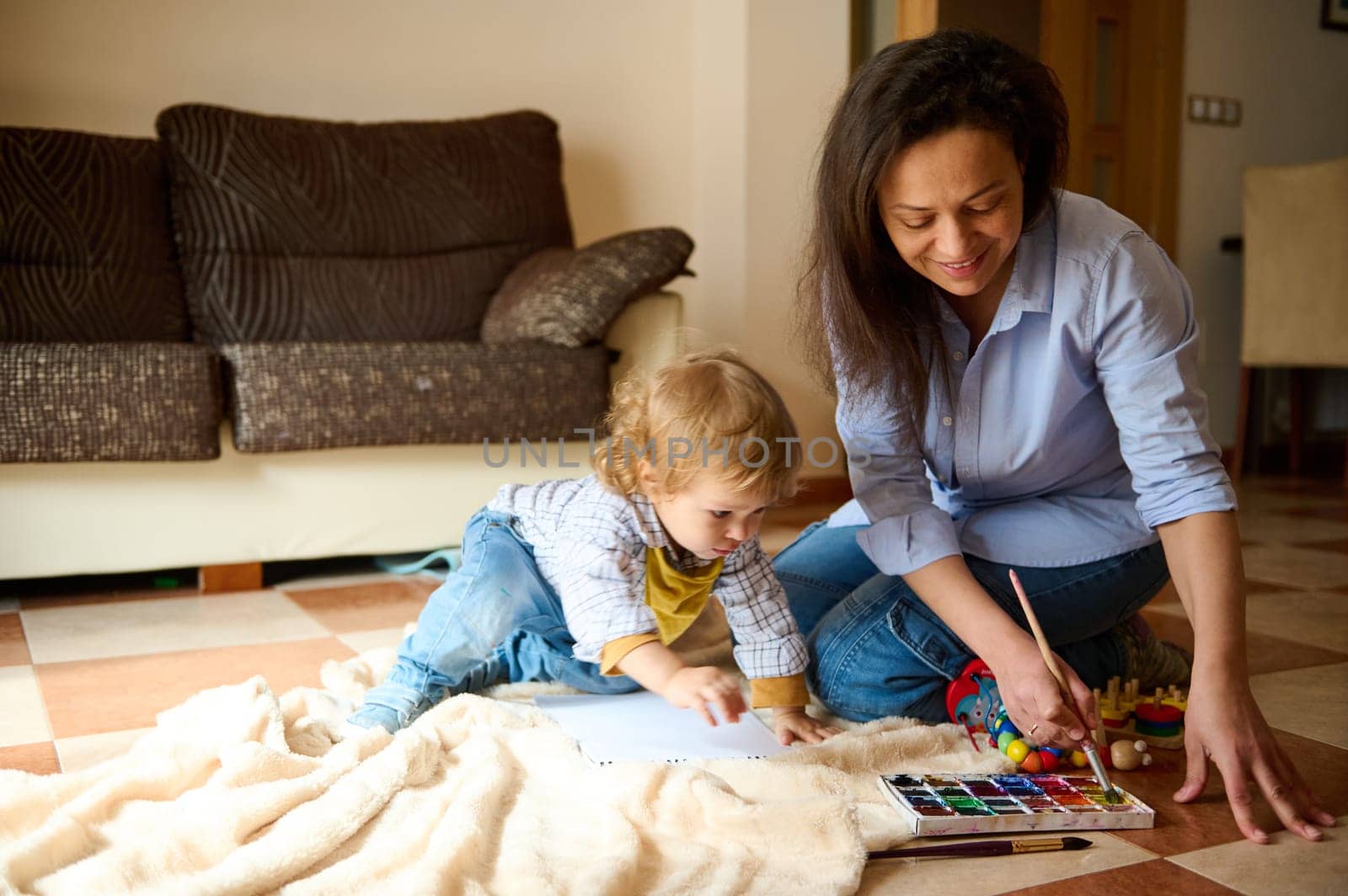 A mother and her young child engage in painting activities together in the living room, fostering creativity and bonding.