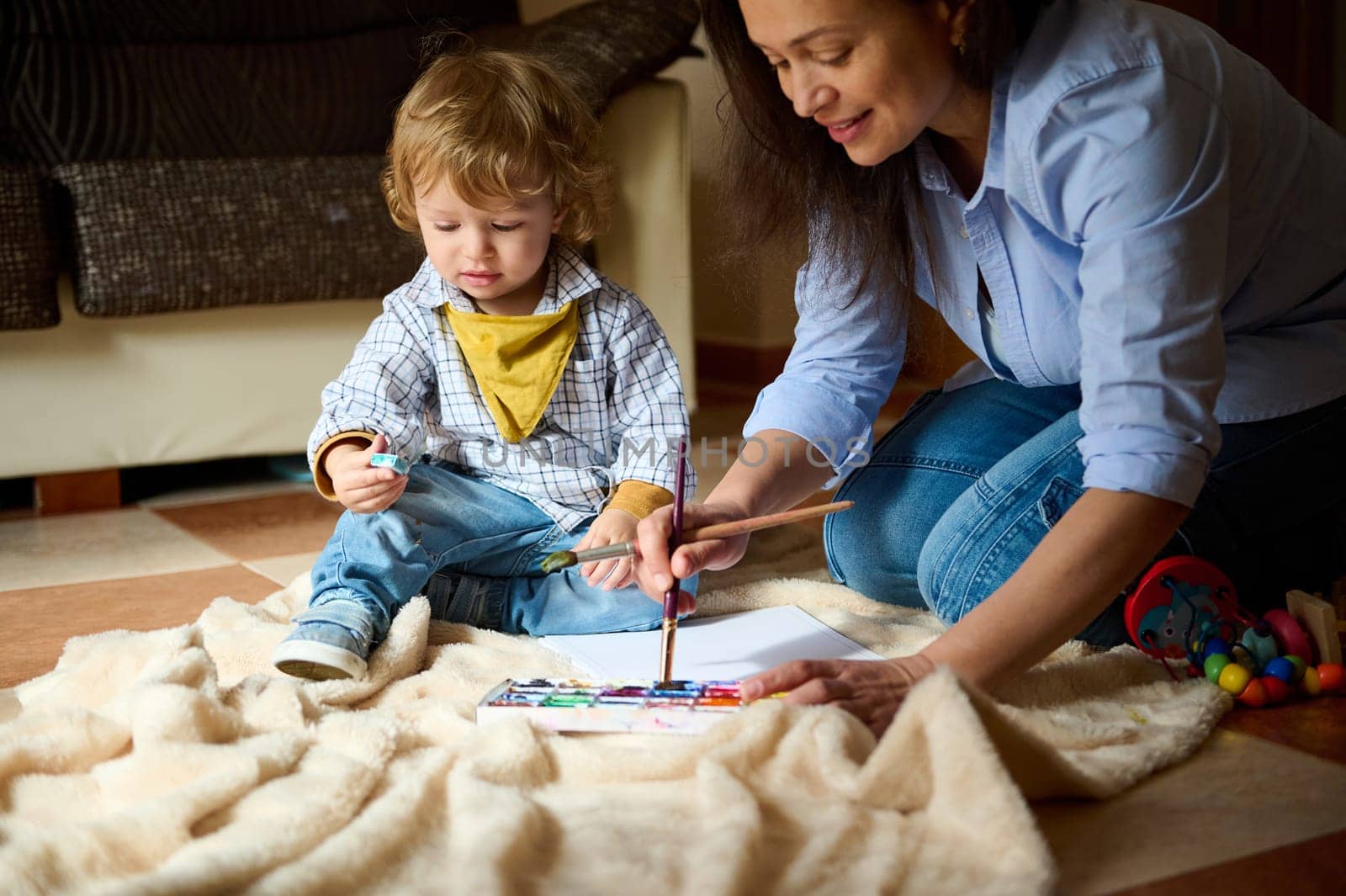 A happy moment of a mother and child enjoying painting together indoors, highlighting parental bonding, art creativity, and emotional warmth.