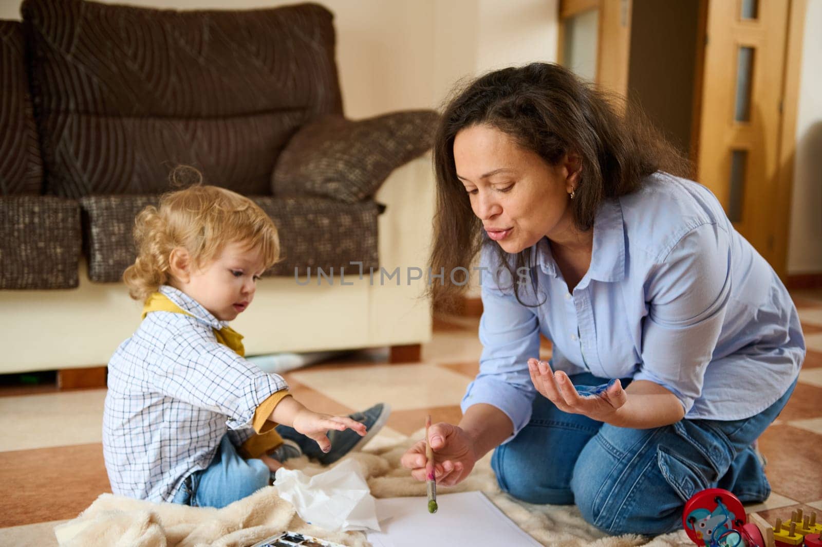 A heartwarming moment of a mother and her young child enjoying creative learning indoors, emphasizing care, education, and family bonding.