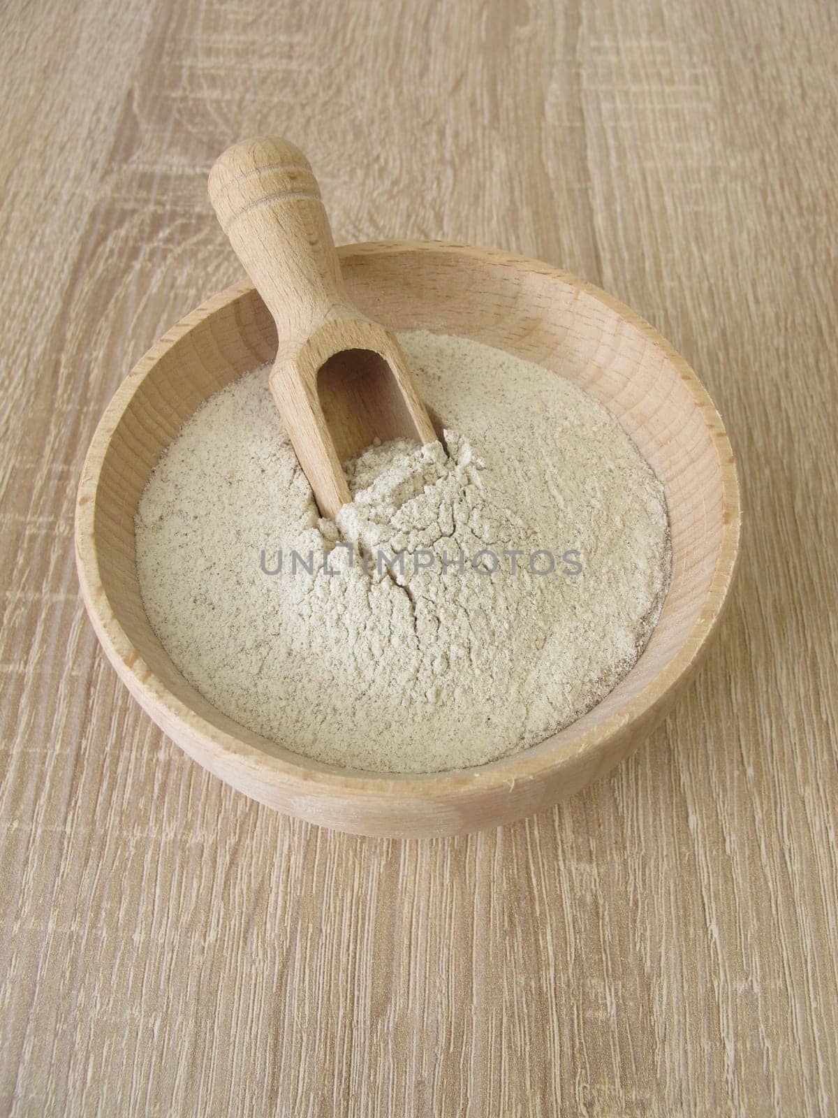 Banana flour from green plantains in a wooden bowl
