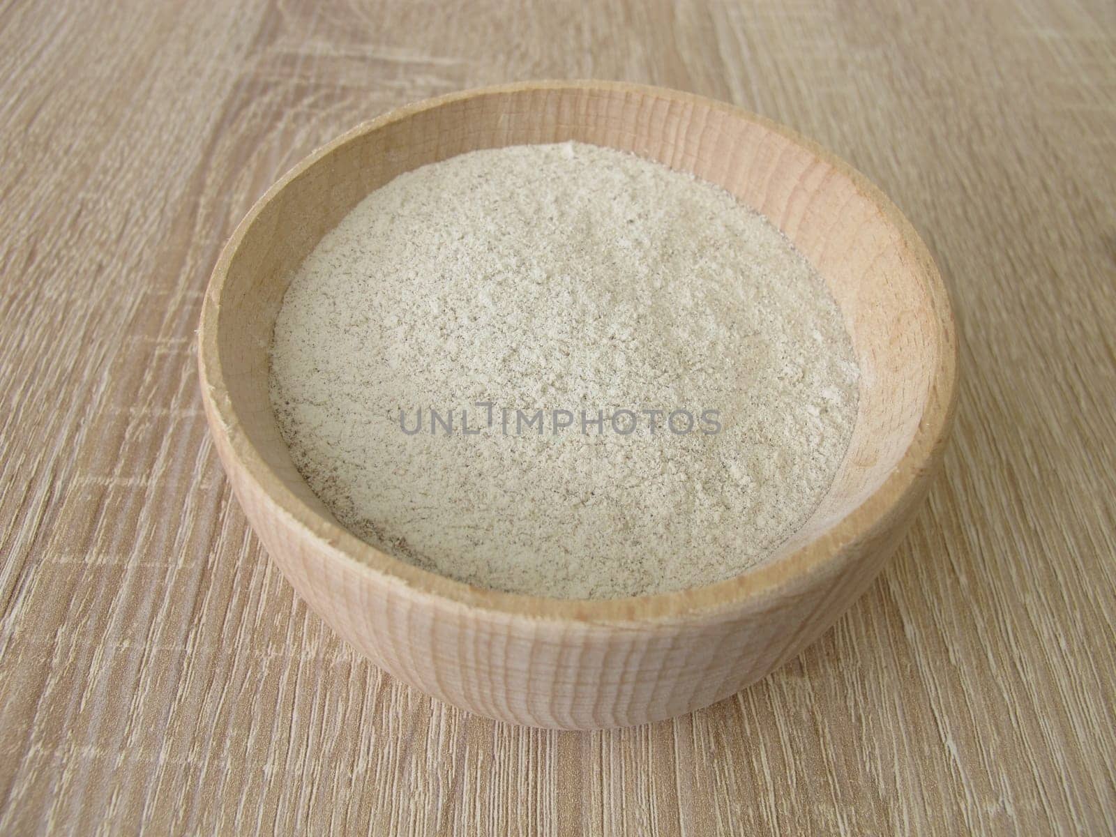 Banana flour from green plantains in a wooden bowl