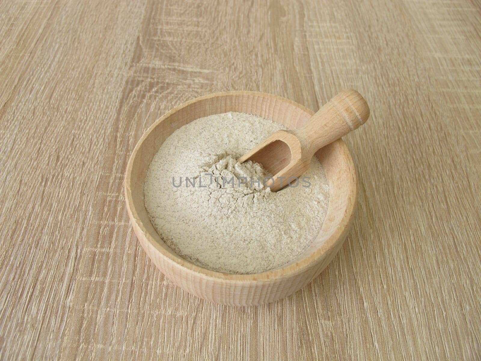 Banana flour from green plantains in a wooden bowl