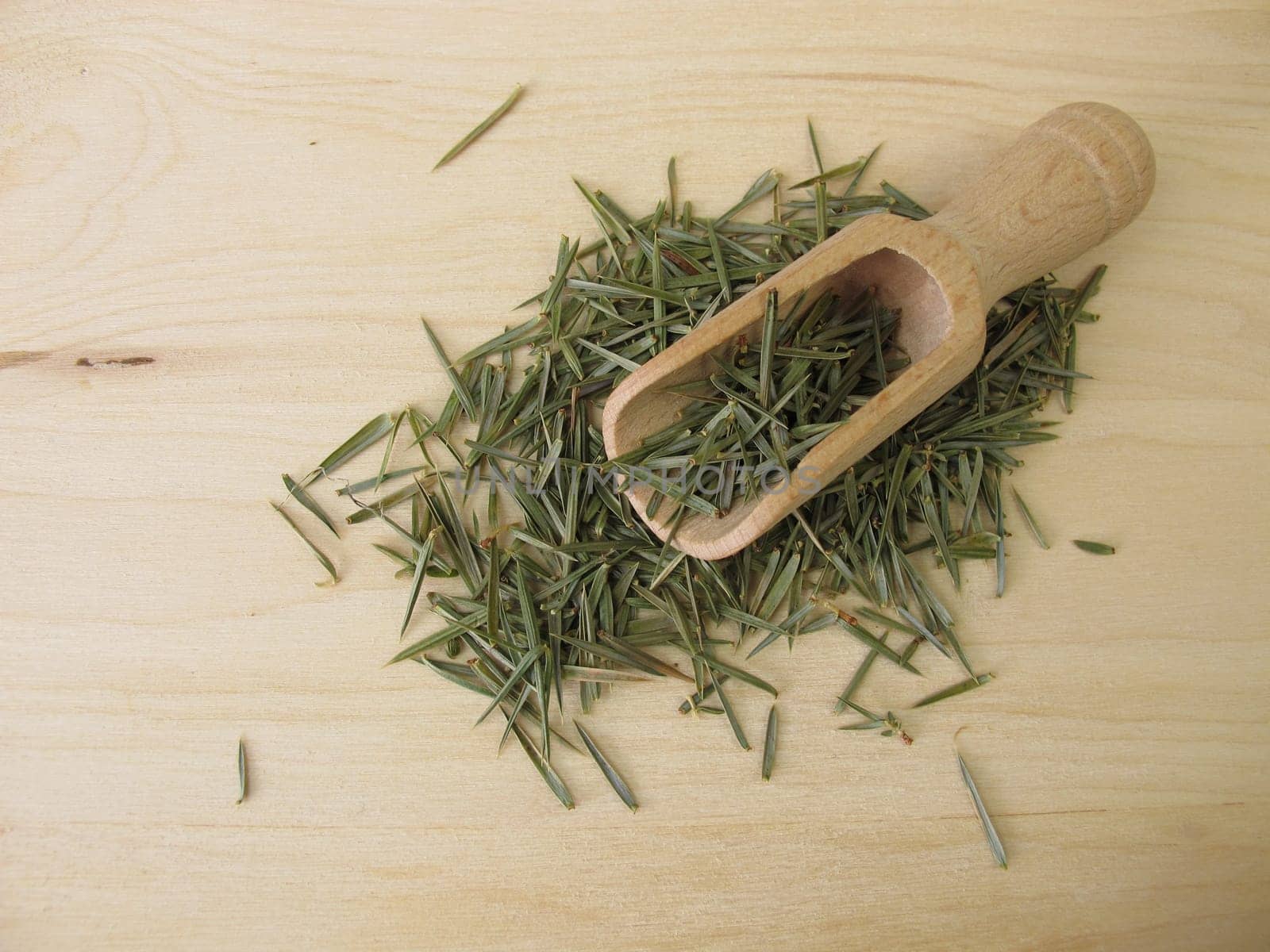Dried juniper needles on a wooden board