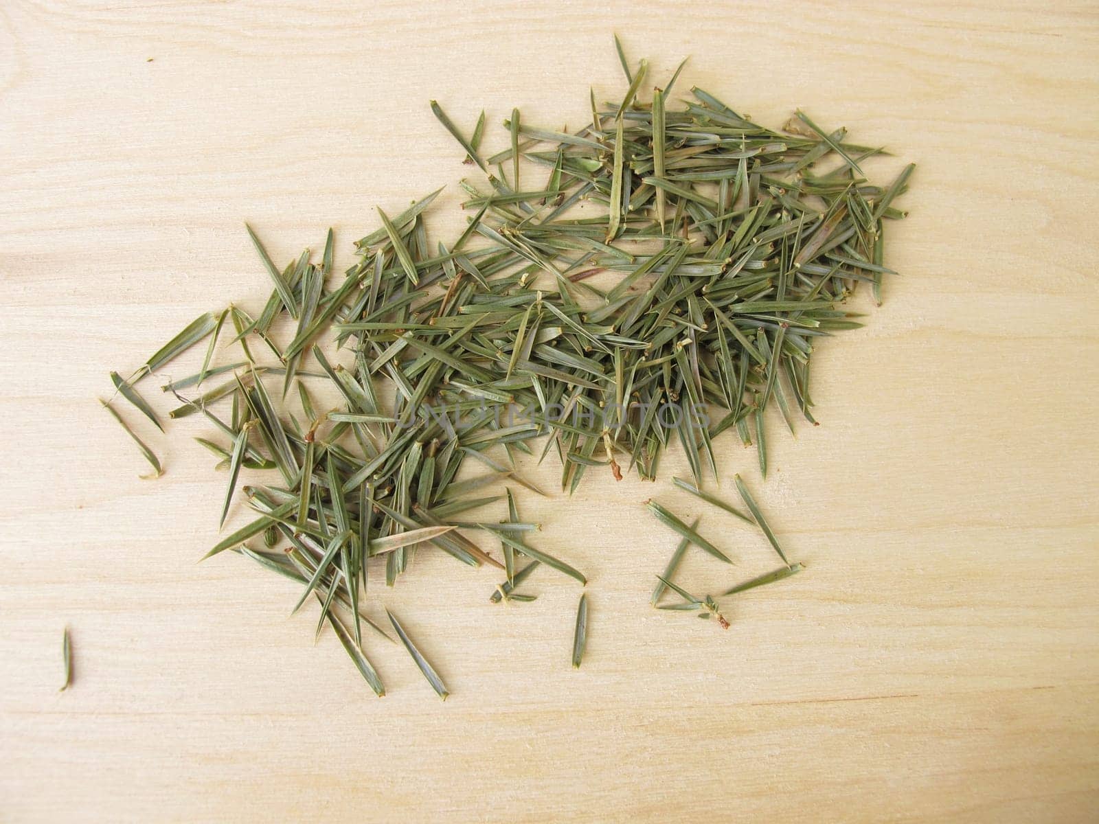 Dried juniper needles on a wooden board