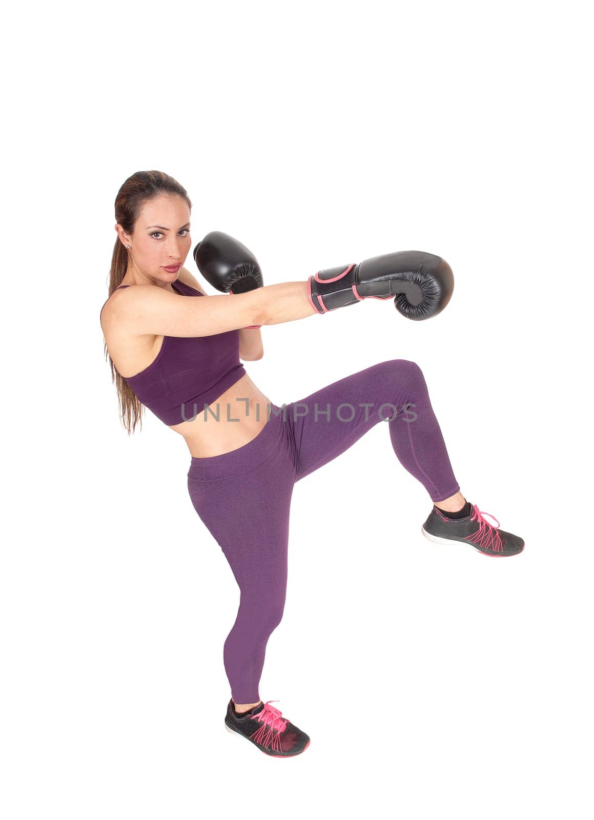 A full body image of a woman boxing and in workout outfits standing.with one leg up, isolated for white background.