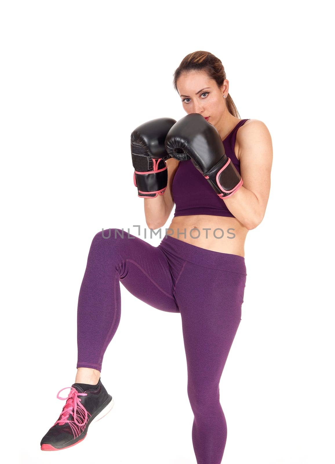 A full body image of a woman boxing and in workout outfits standing.with one leg up, isolated for white background.