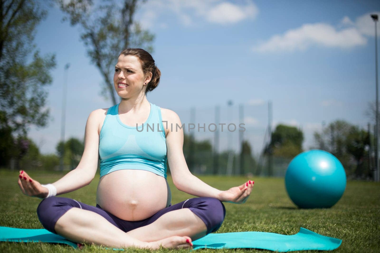 Healthy pregnant woman doing yoga in nature