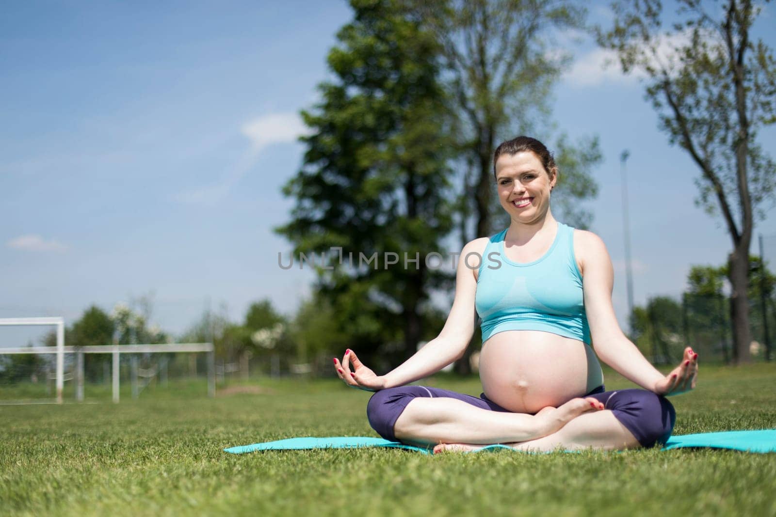 Healthy pregnant woman doing yoga in nature