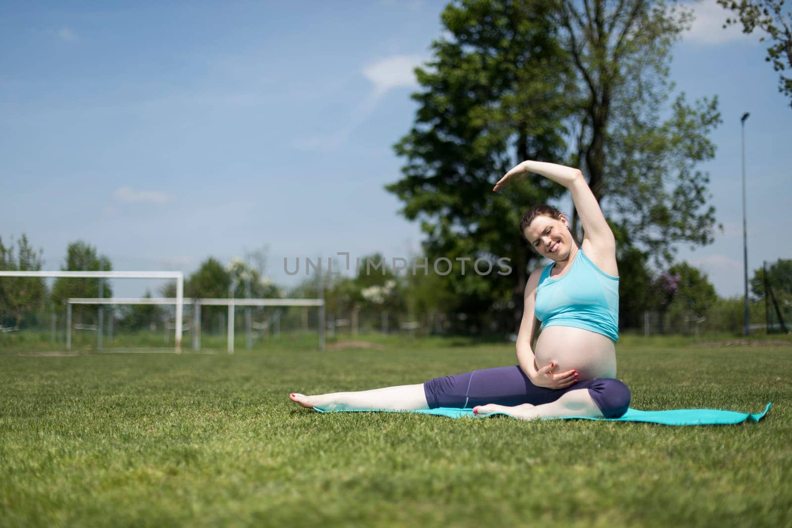 Healthy pregnant woman doing yoga in nature