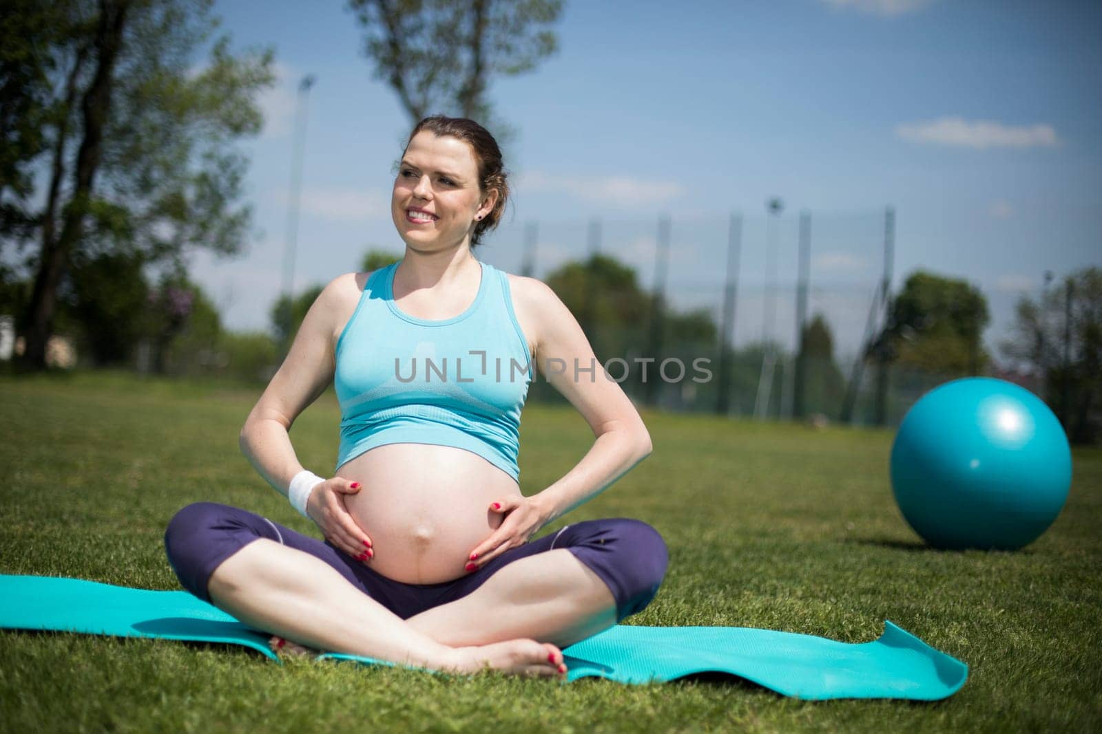 Pregnant woman doing yoga in nature