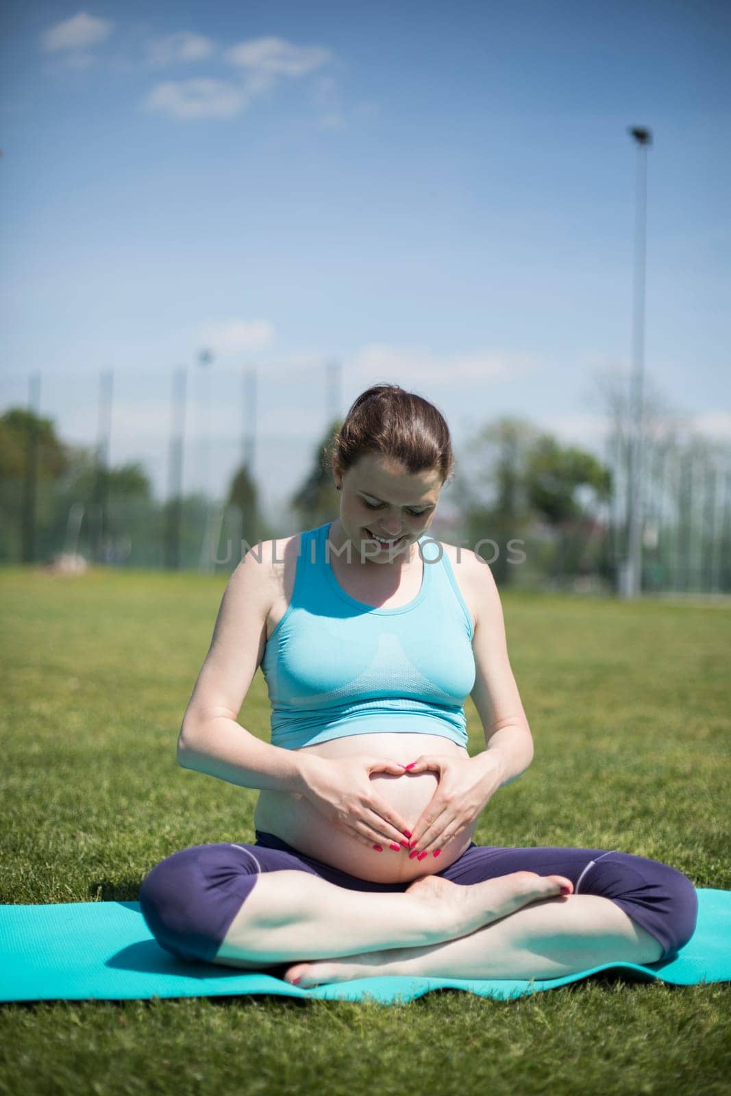 Healthy pregnant woman doing yoga in nature