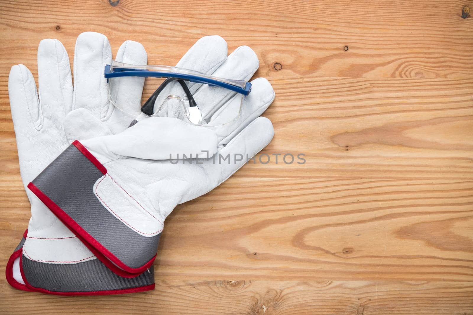 goggles and work gloves on wooden ground