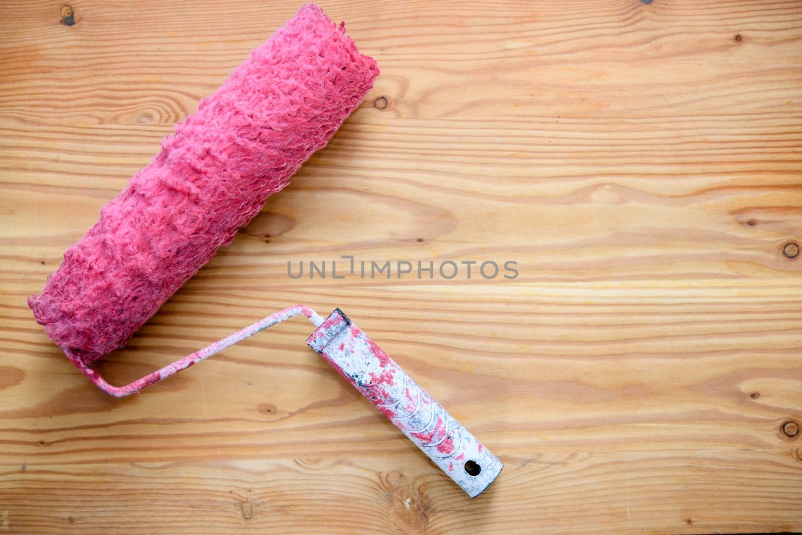 big red  used paint roller wooden ground