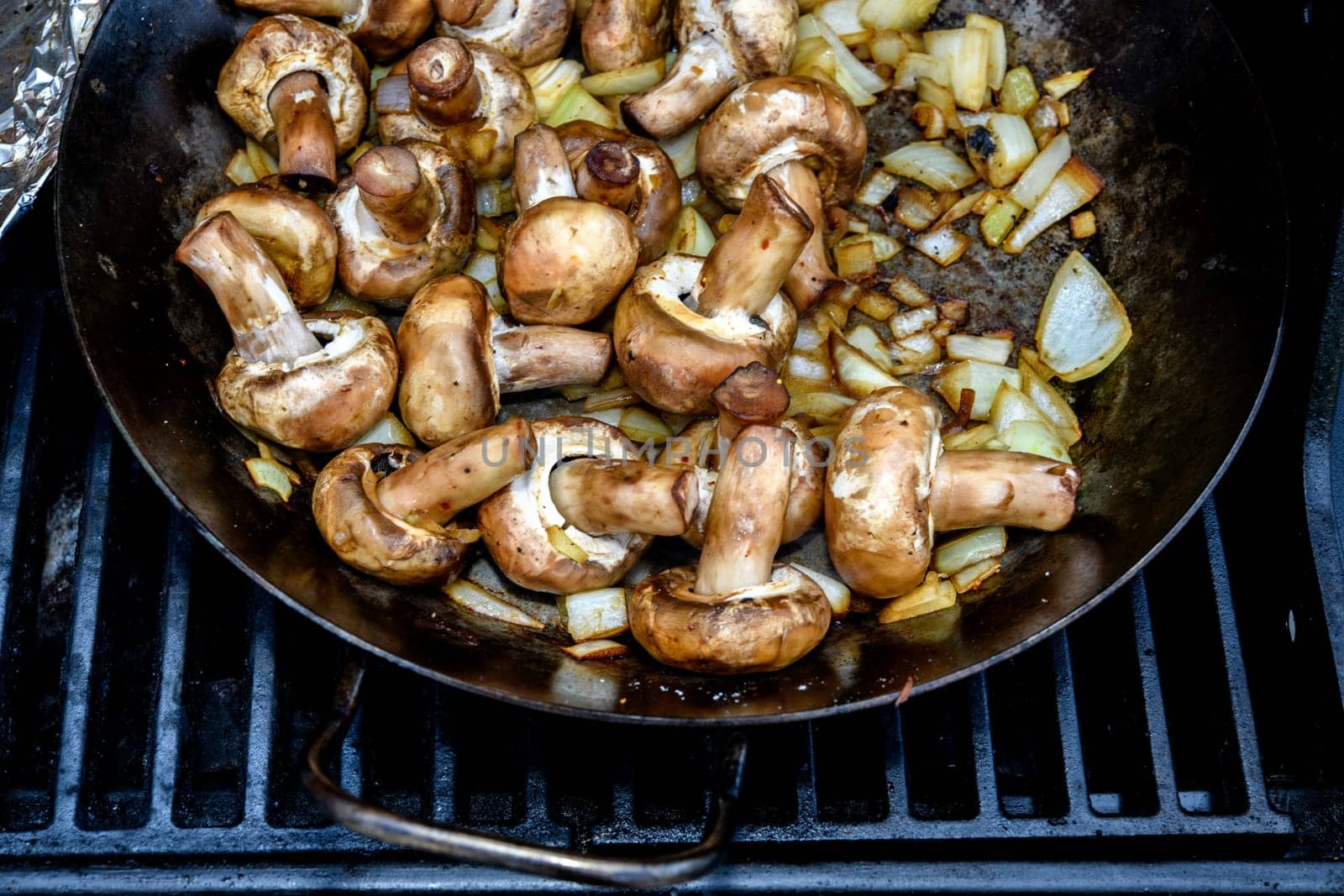 a lot of grilled mushrooms in pan on barbecue