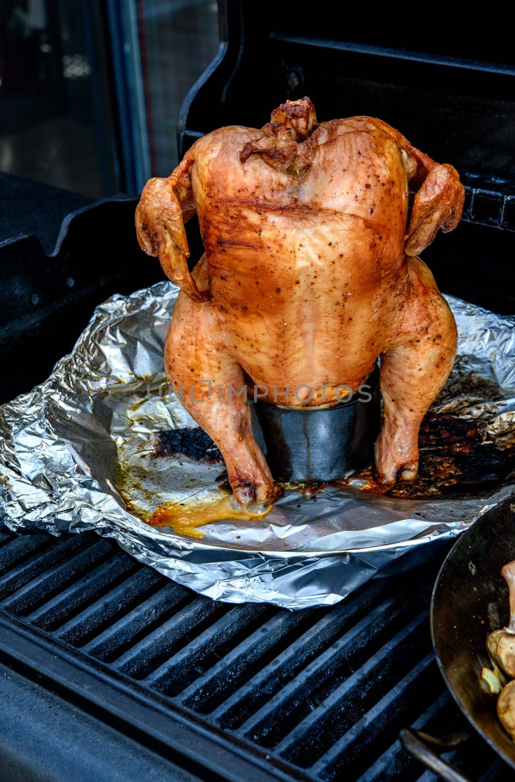crunchy grilled completely chicken sitting on  barbecue