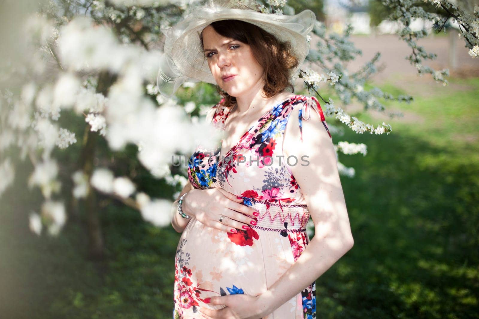 Beautiful pregnant woman relaxing outside in the Orchard