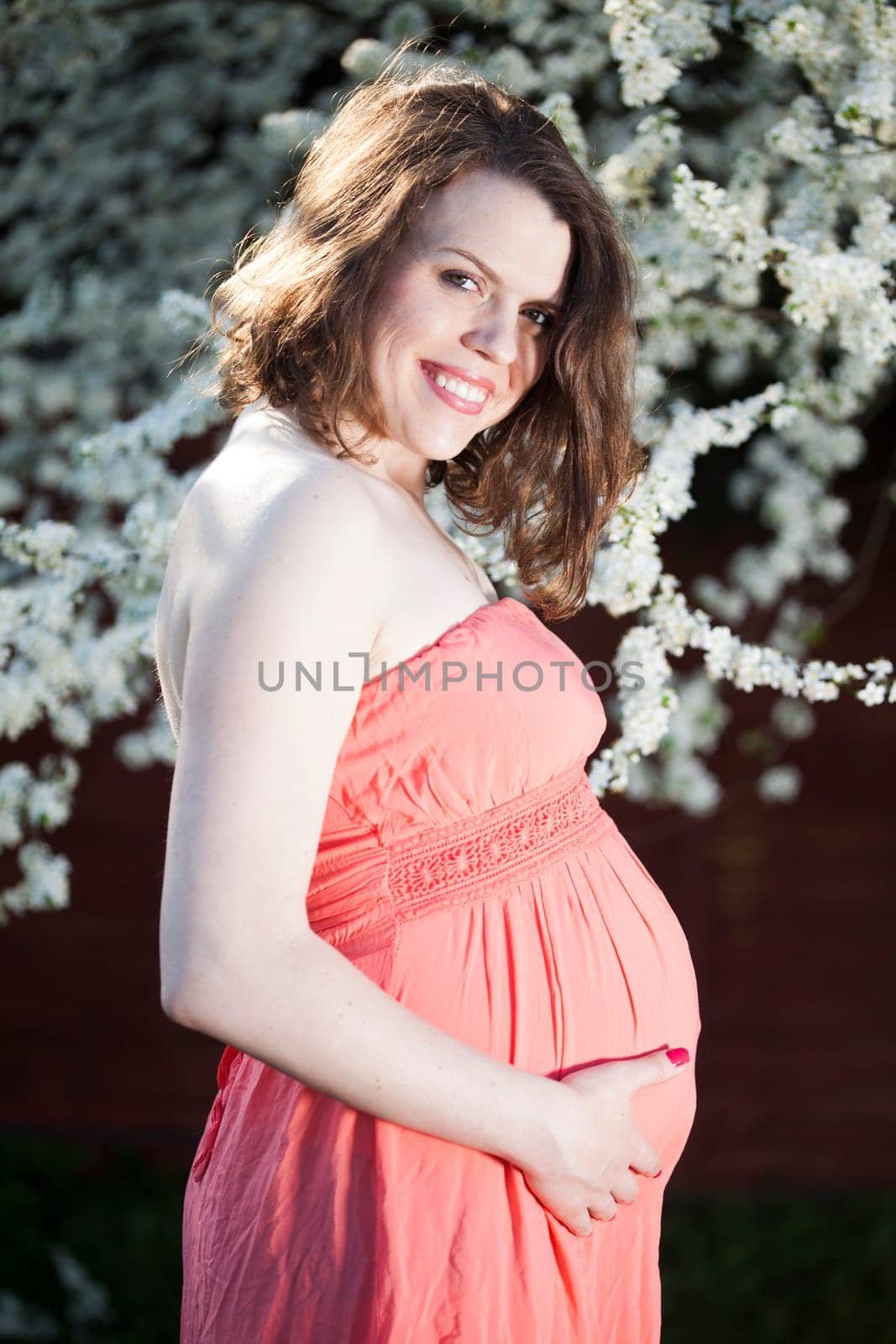 Beautiful pregnant woman relaxing outside in the Orchard