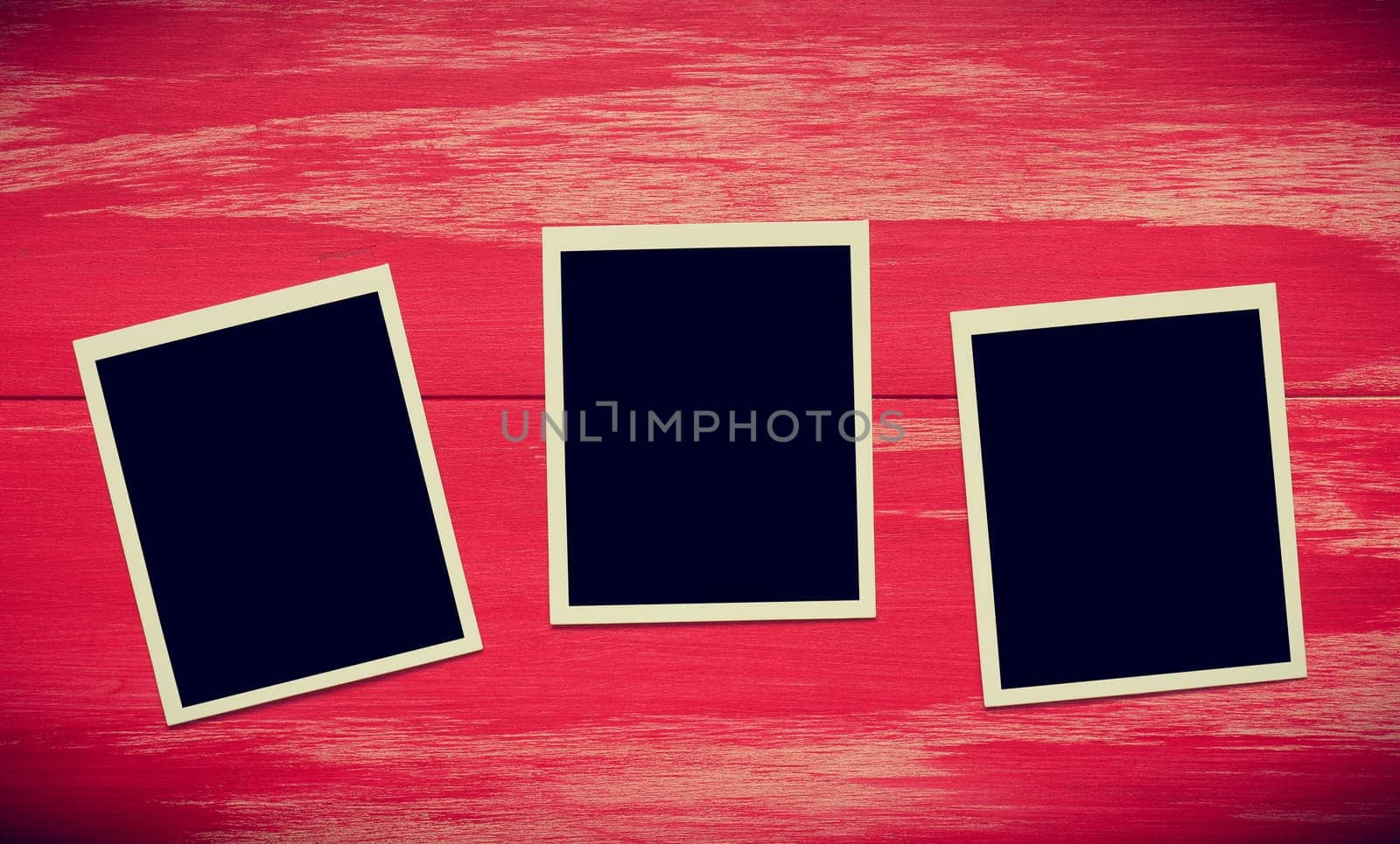 Vintage photo frames on a rustic red wooden background