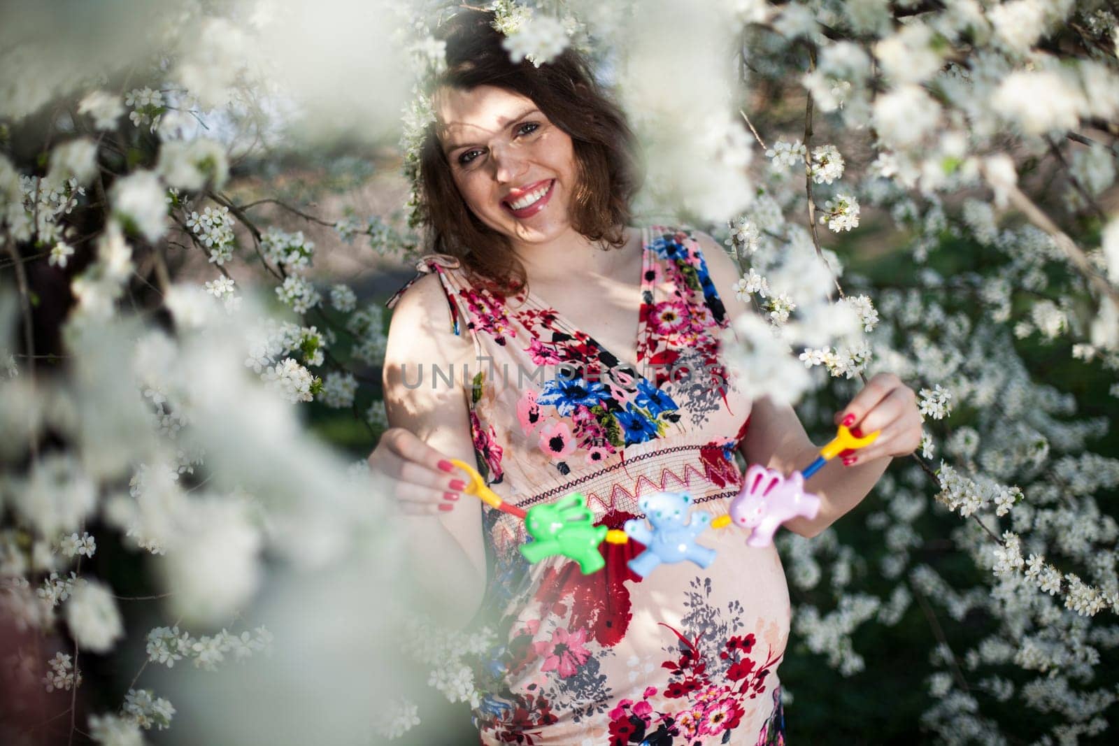 Young beautiful pregnant woman, blooming garden