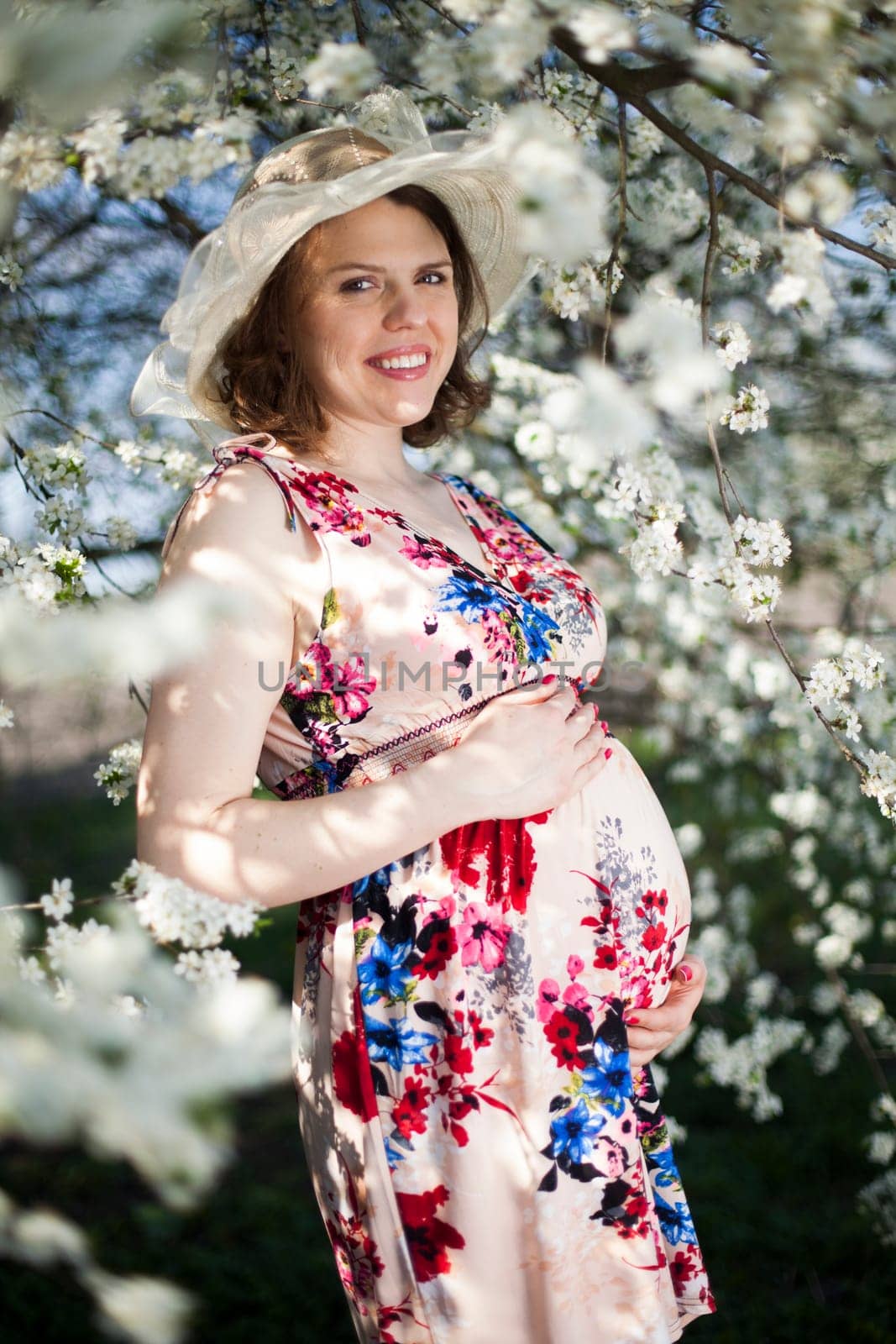 Beautiful pregnant woman relaxing outside in the Orchard