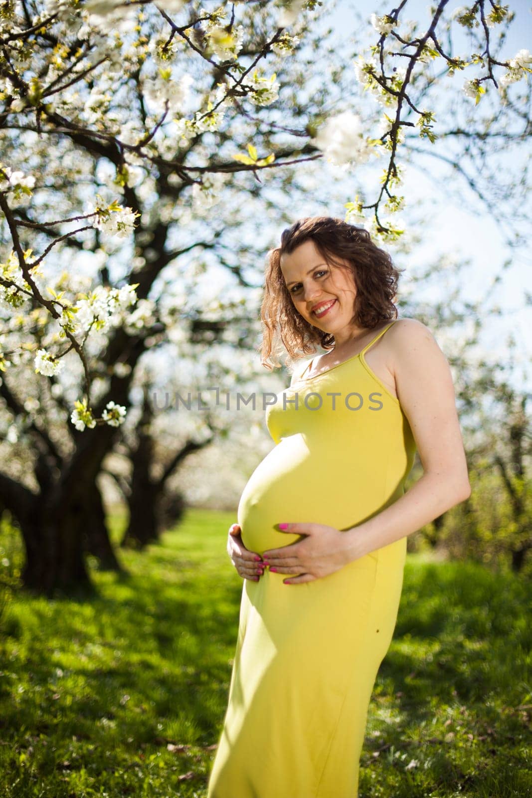 Beautiful pregnant woman relaxing outside in the Orchard