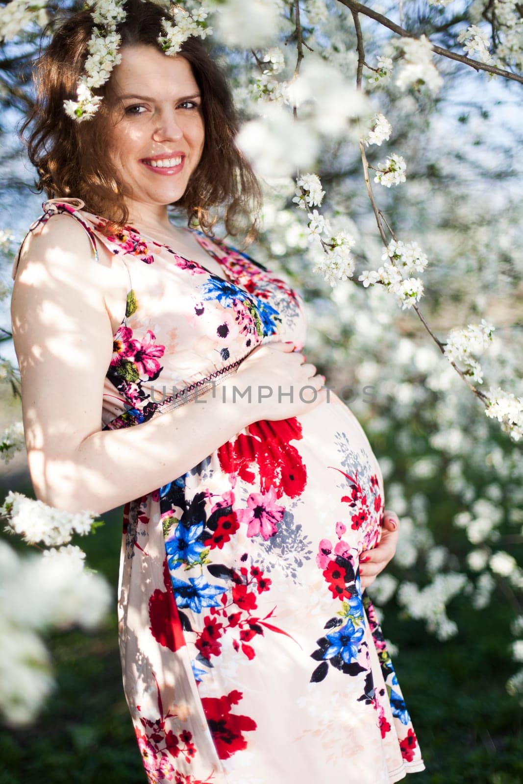 Beautiful pregnant woman relaxing outside in the Orchard