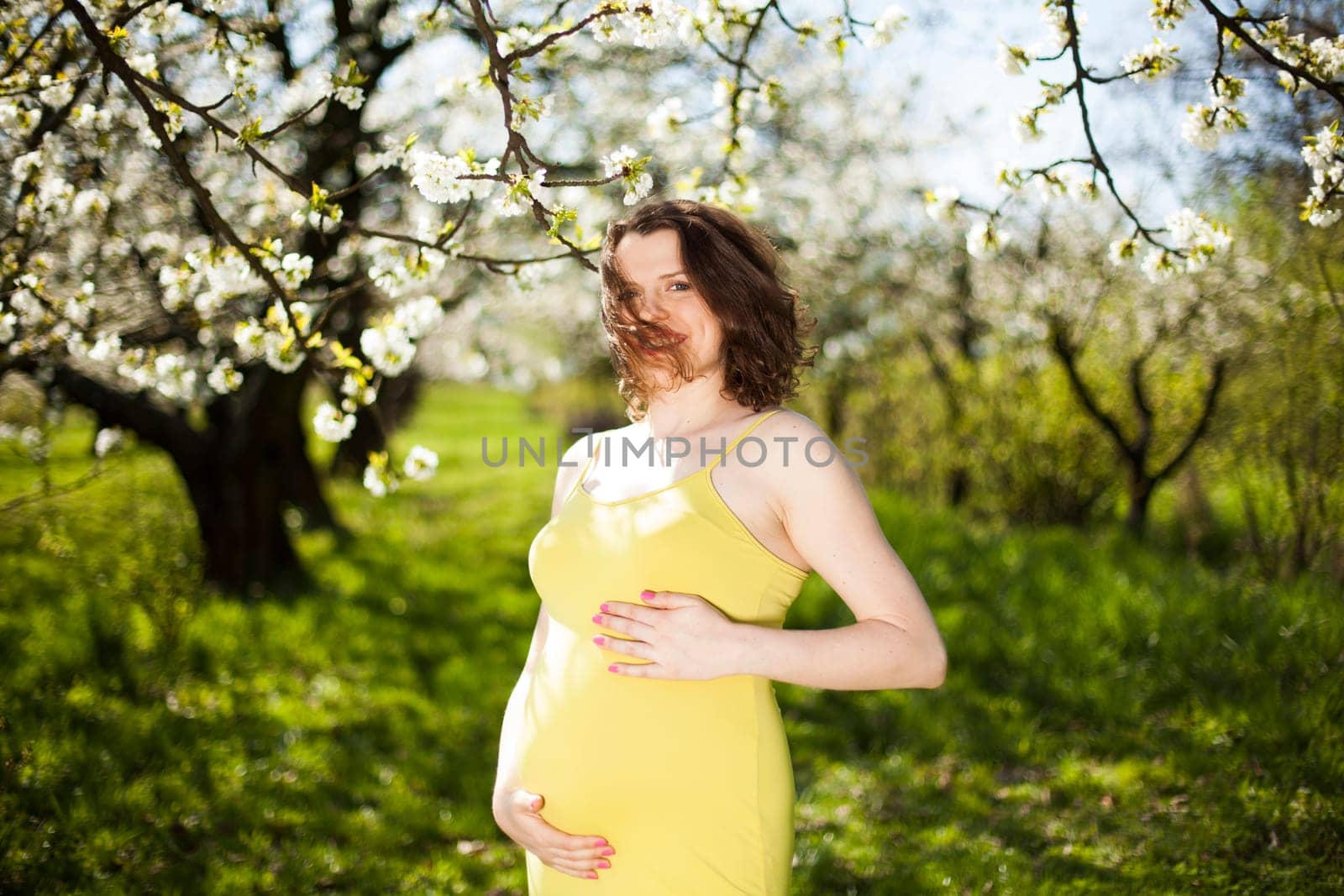 Spring, Young beautiful pregnant woman in the Orchard