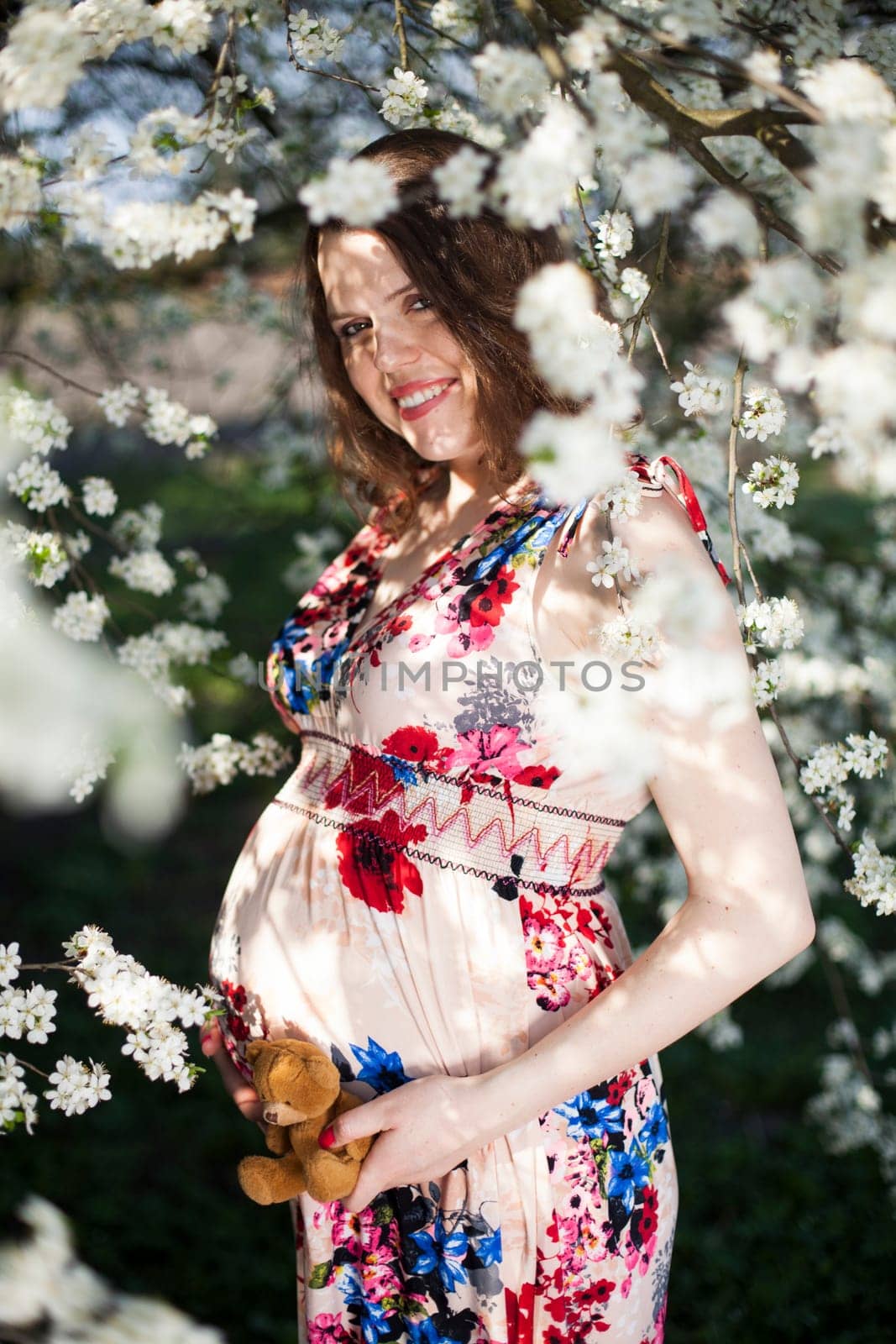 Beautiful pregnant woman relaxing outside in the Orchard