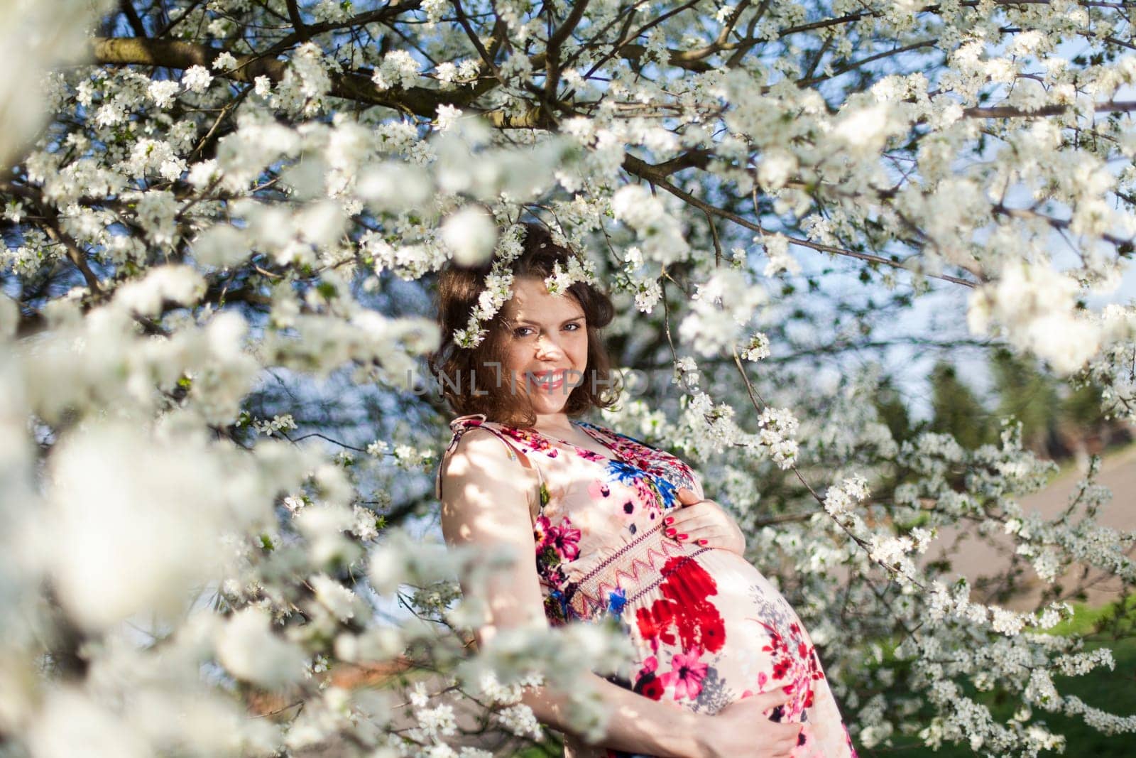 Beautiful pregnant woman relaxing outside in the Orchard