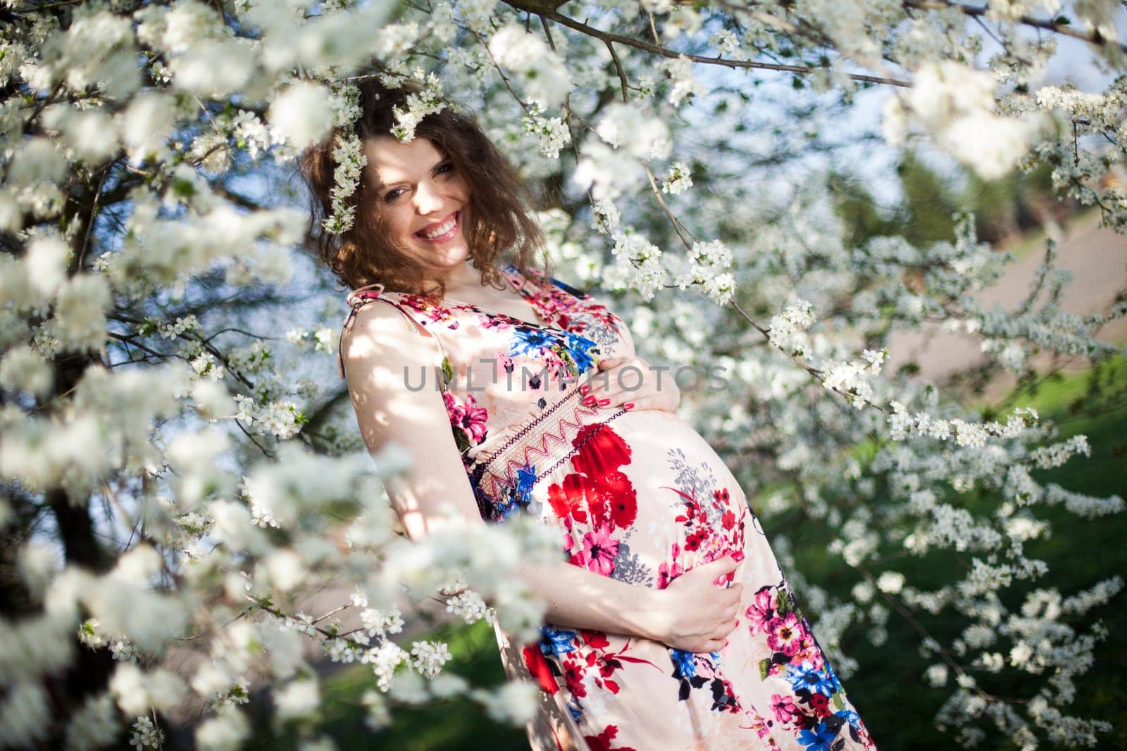 Beautiful pregnant woman relaxing outside in the Orchard