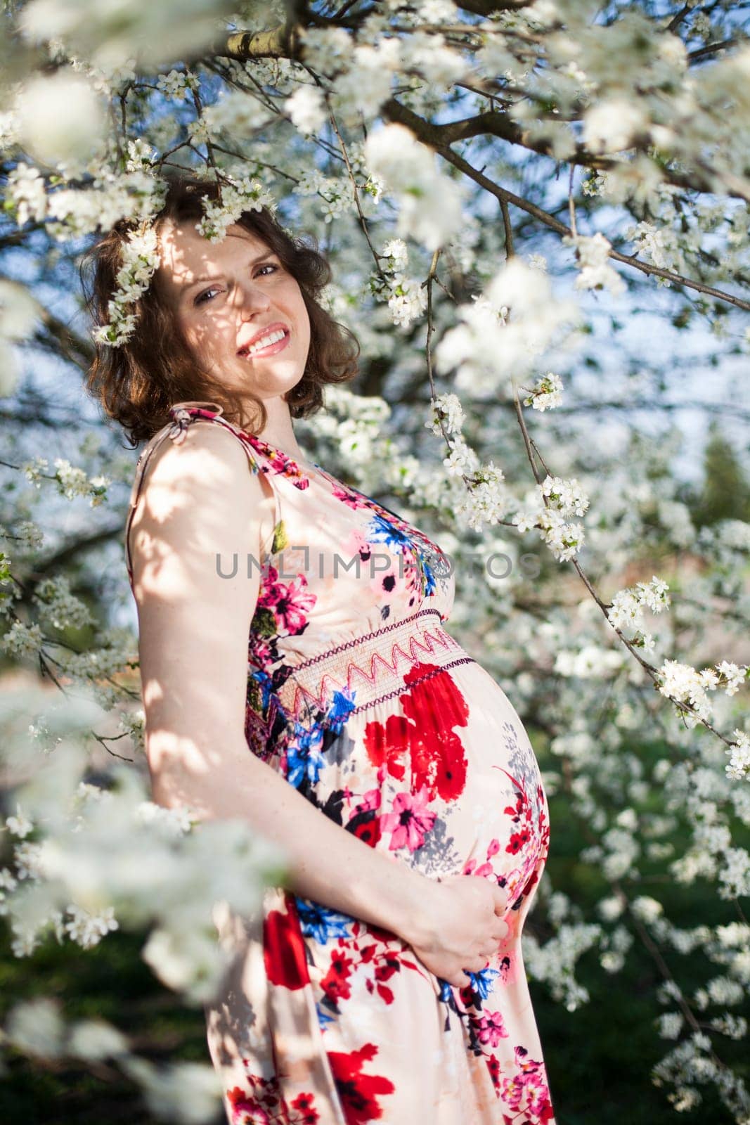 Beautiful pregnant woman relaxing outside in the Orchard