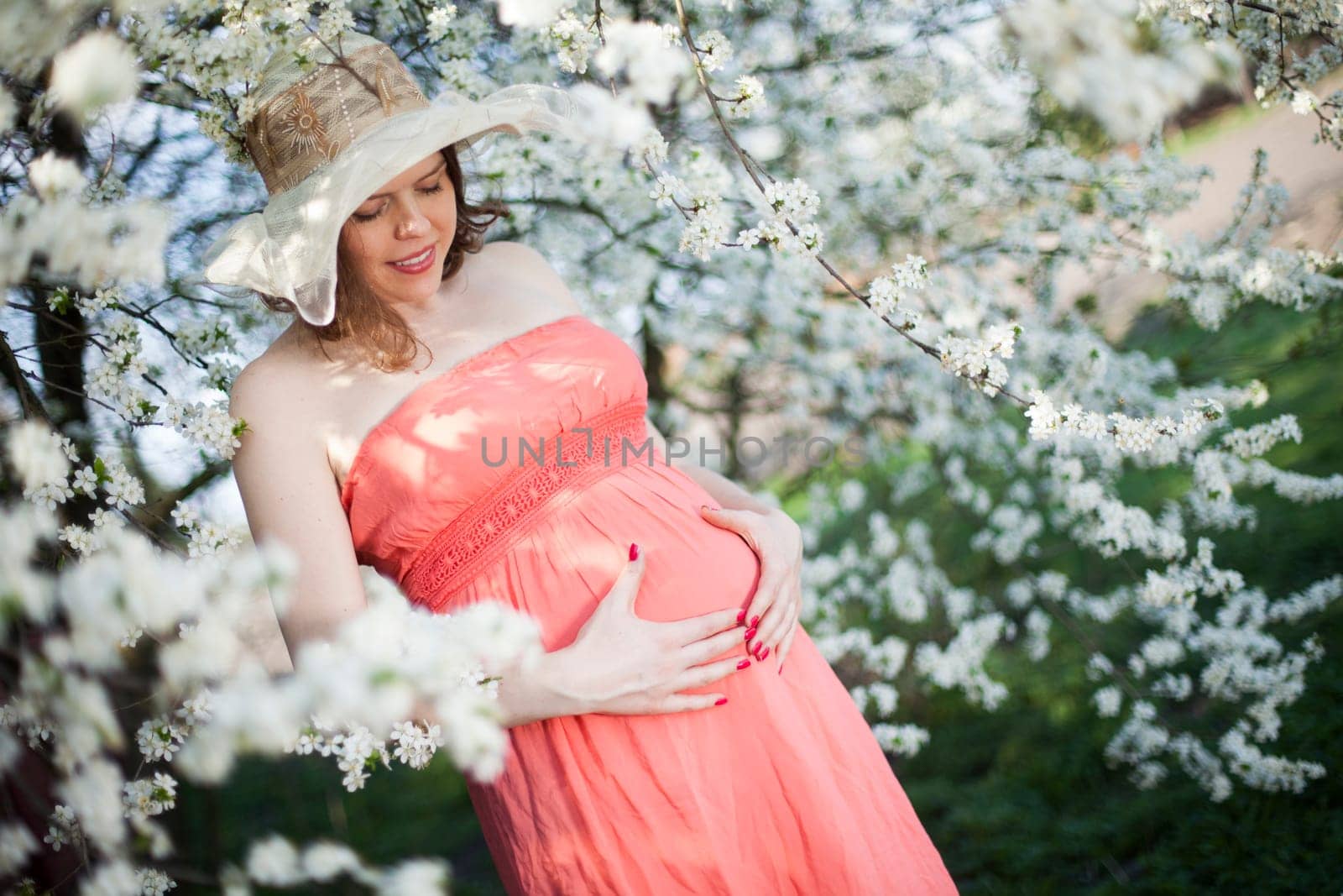 Beautiful pregnant woman relaxing outside in the Orchard