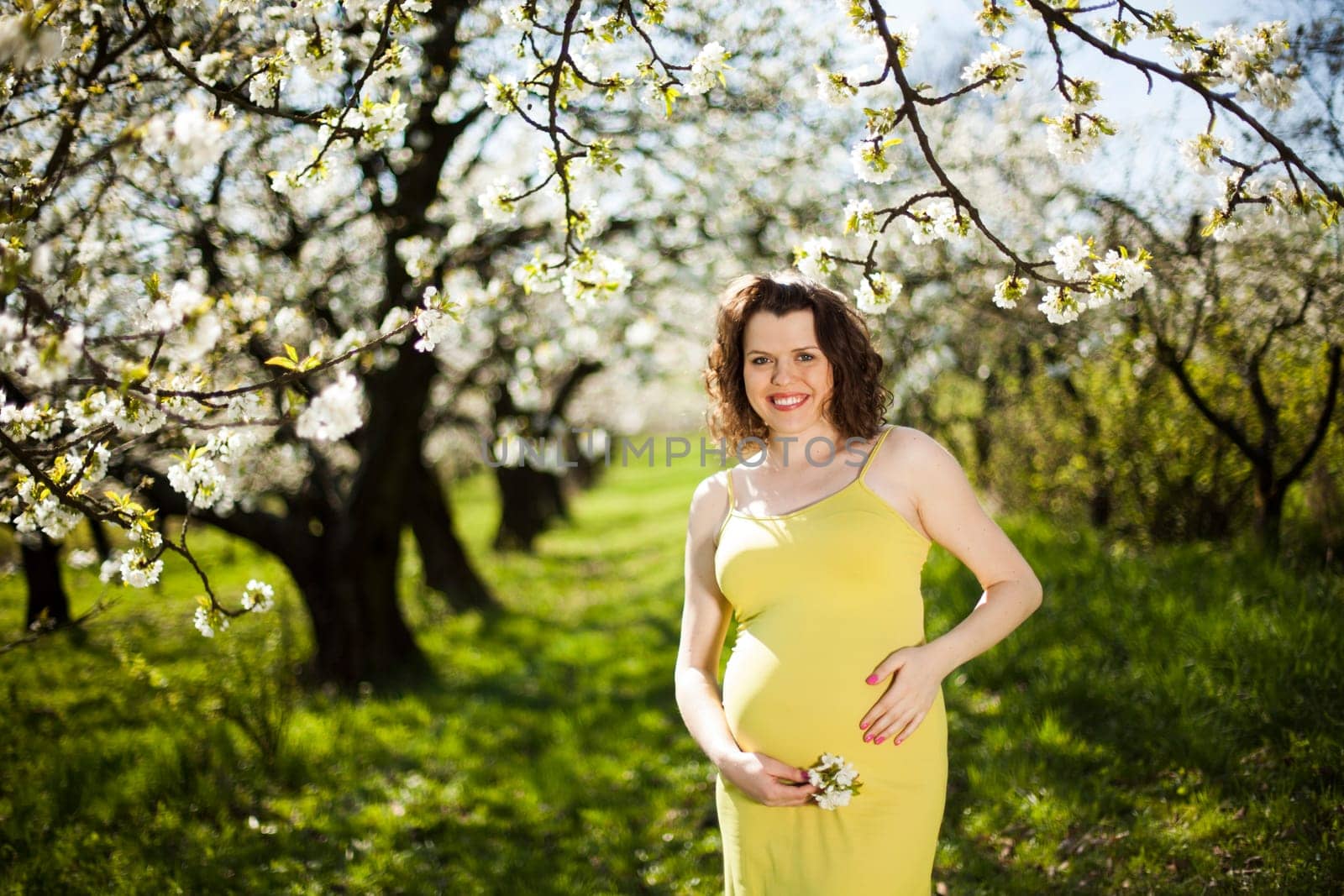 Beautiful pregnant woman relaxing outside in the Orchard