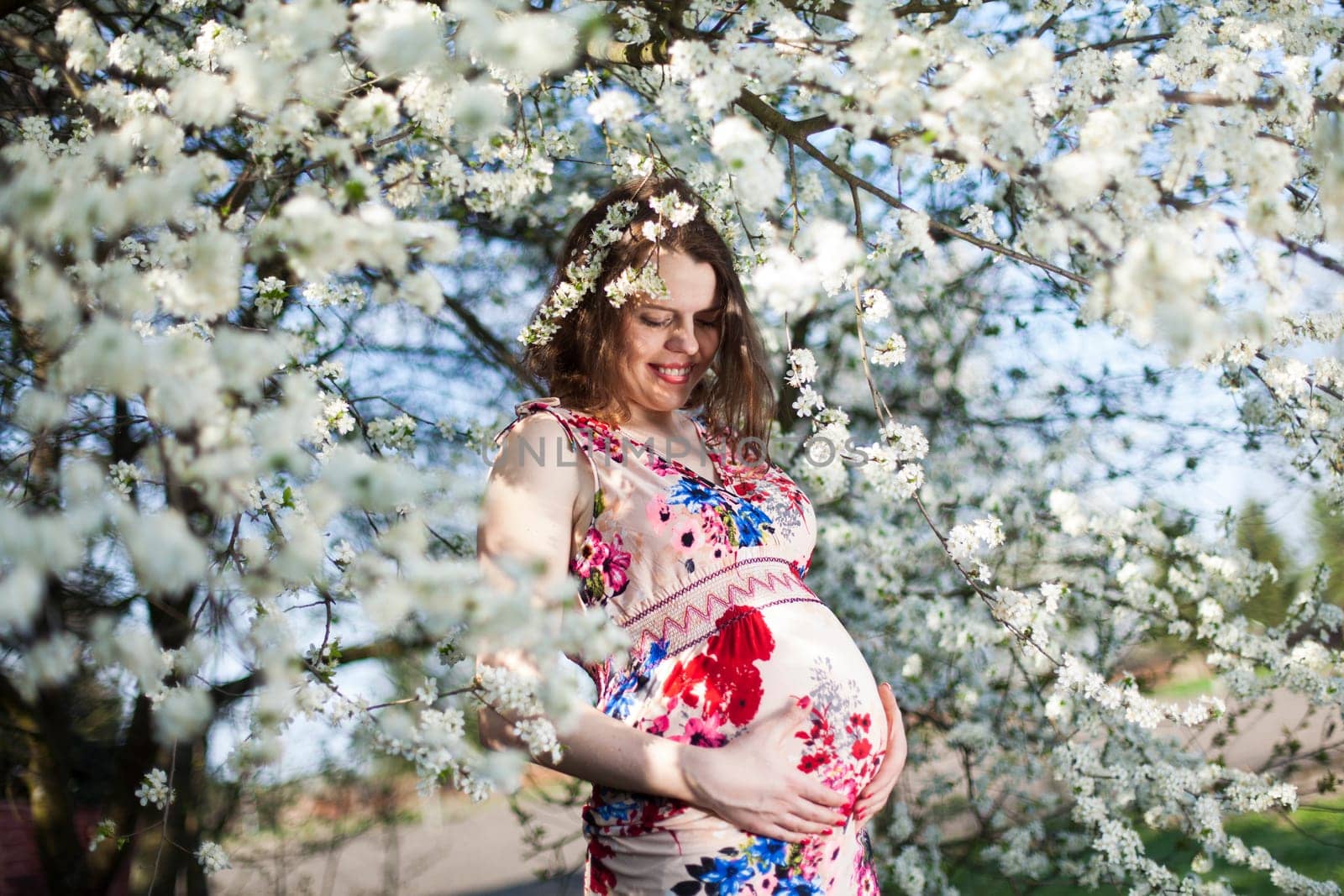 Beautiful pregnant woman relaxing outside in the Orchard