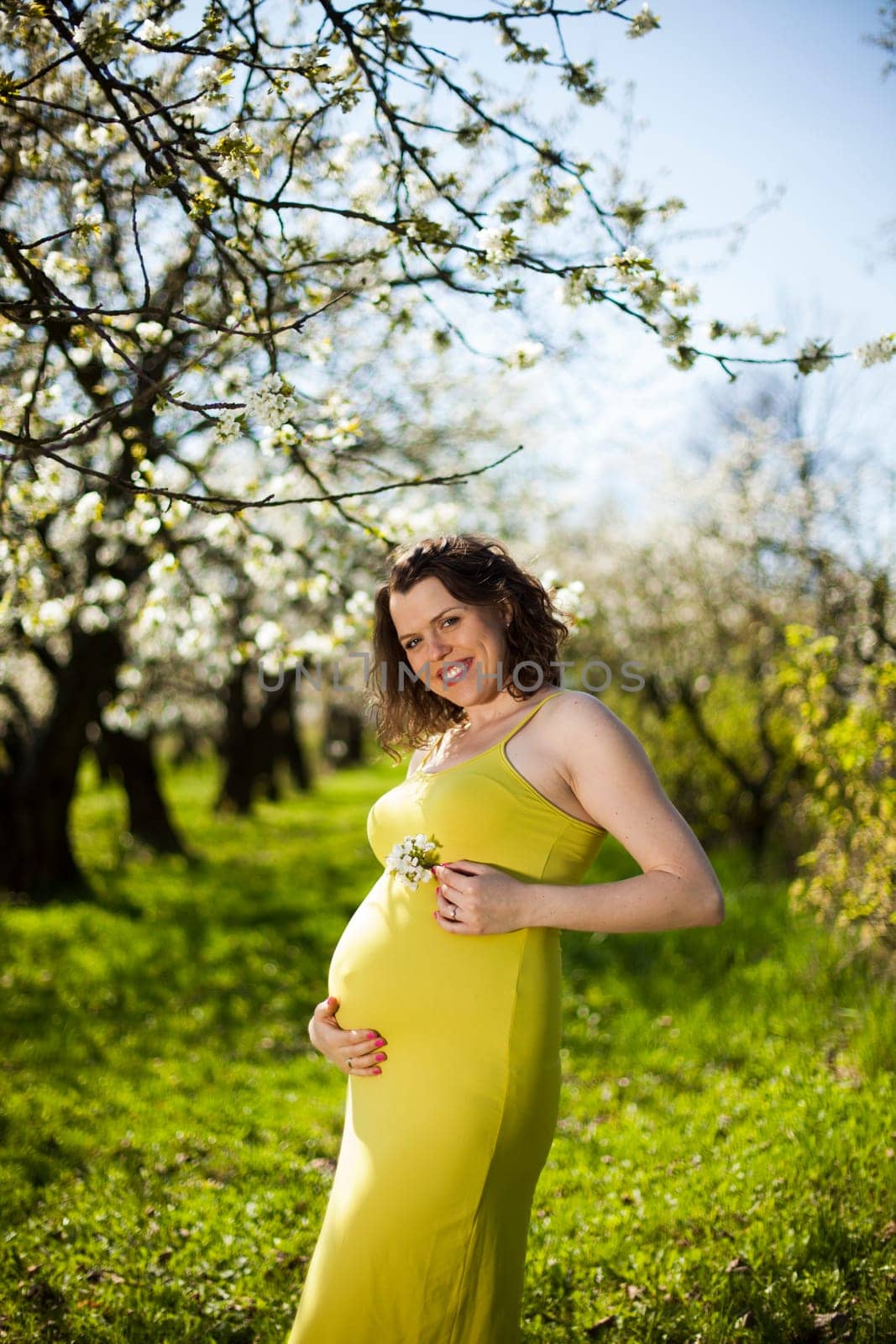 Beautiful pregnant woman relaxing outside in the Orchard