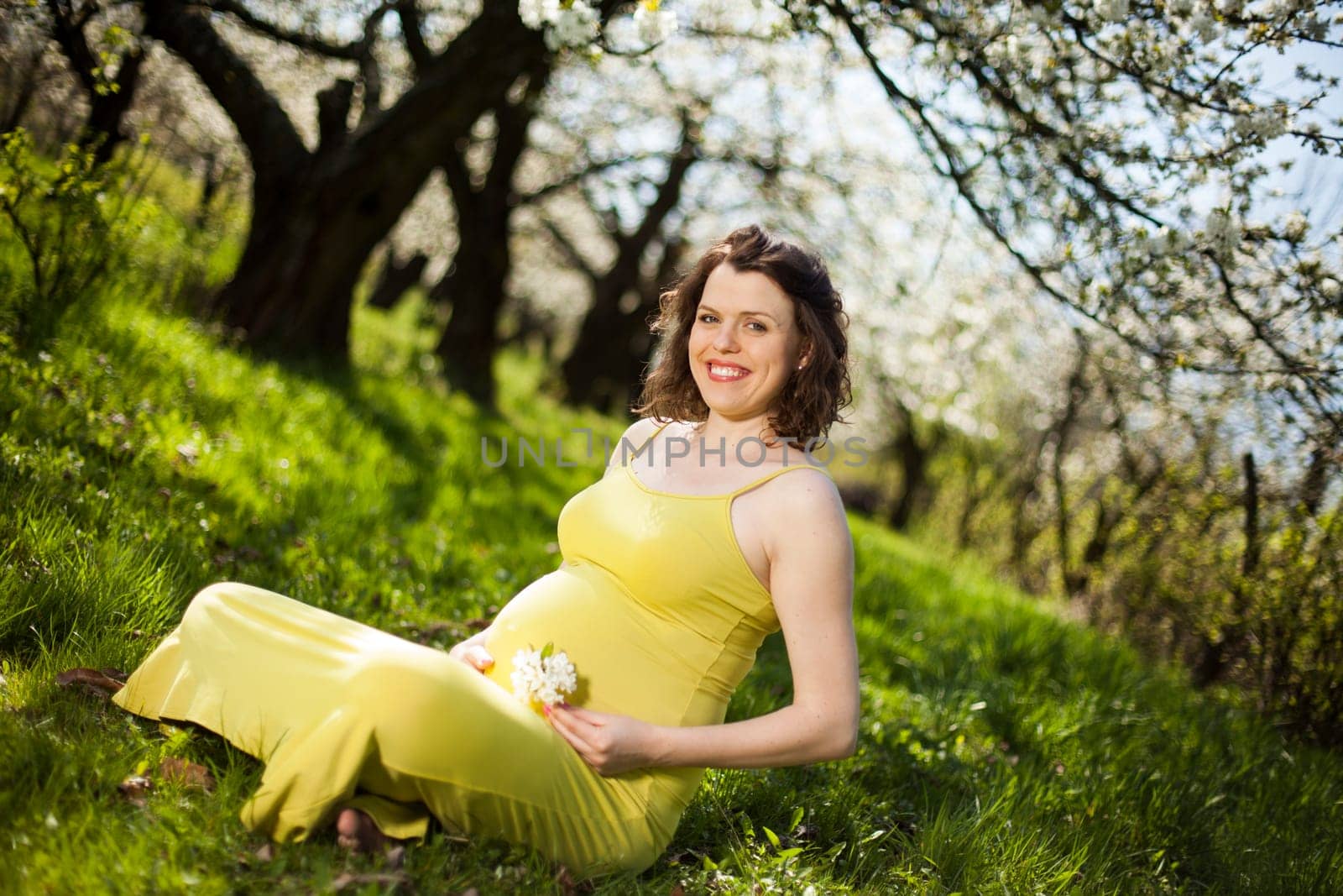 Spring, Young beautiful pregnant woman in the Orchard