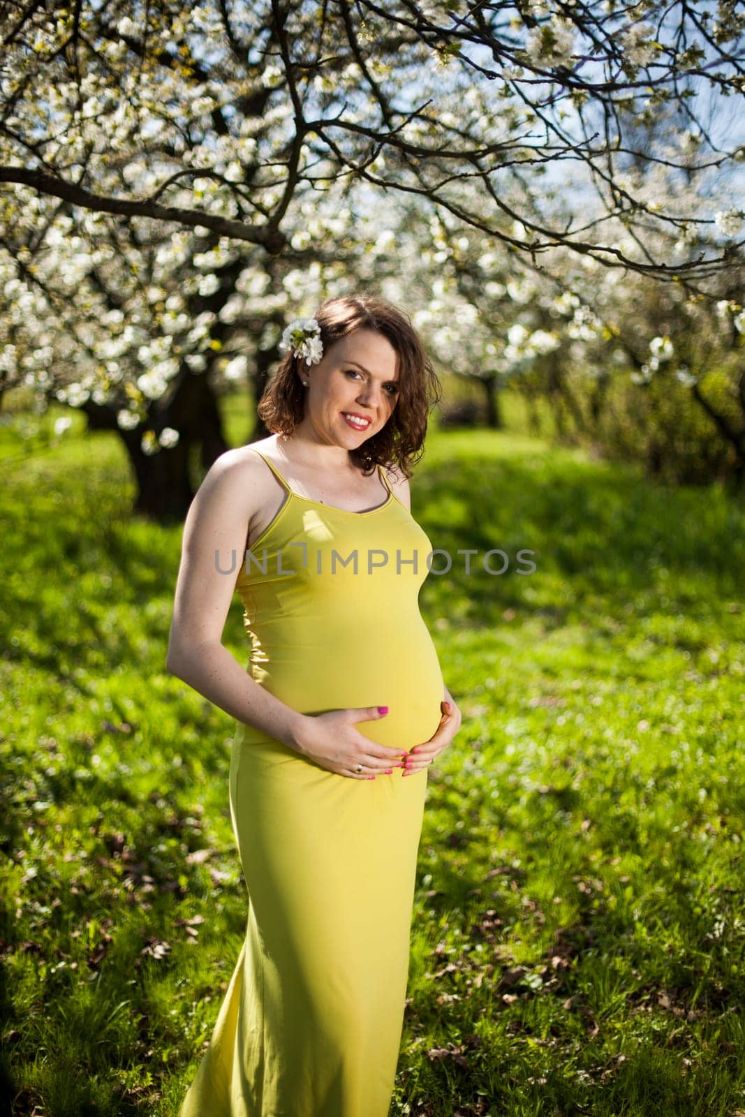 Beautiful pregnant woman relaxing outside in the Orchard