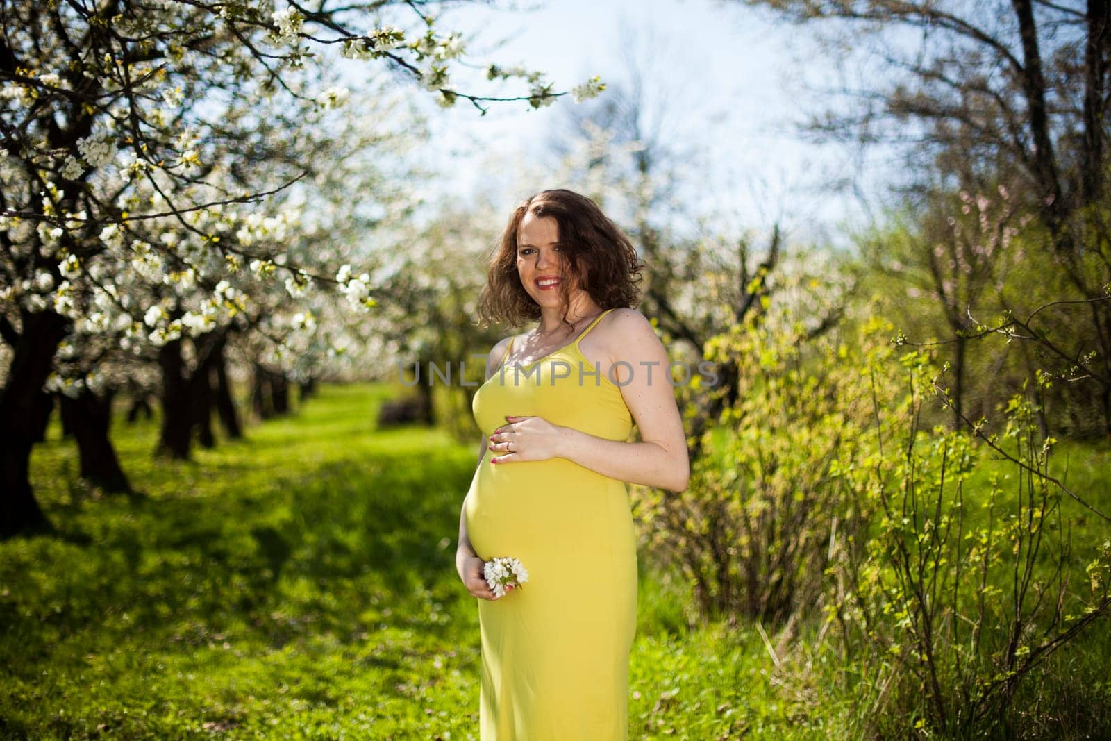 Beautiful pregnant woman relaxing outside in the Orchard